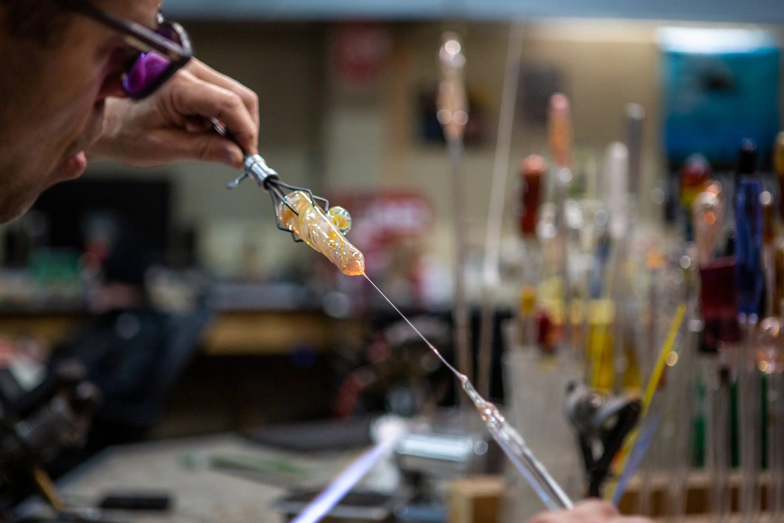 Dave Schuster pulls imperfect glass from one end of the pipe at Skylab Glass in Golden Valley, Minn., on December 6, 2022.