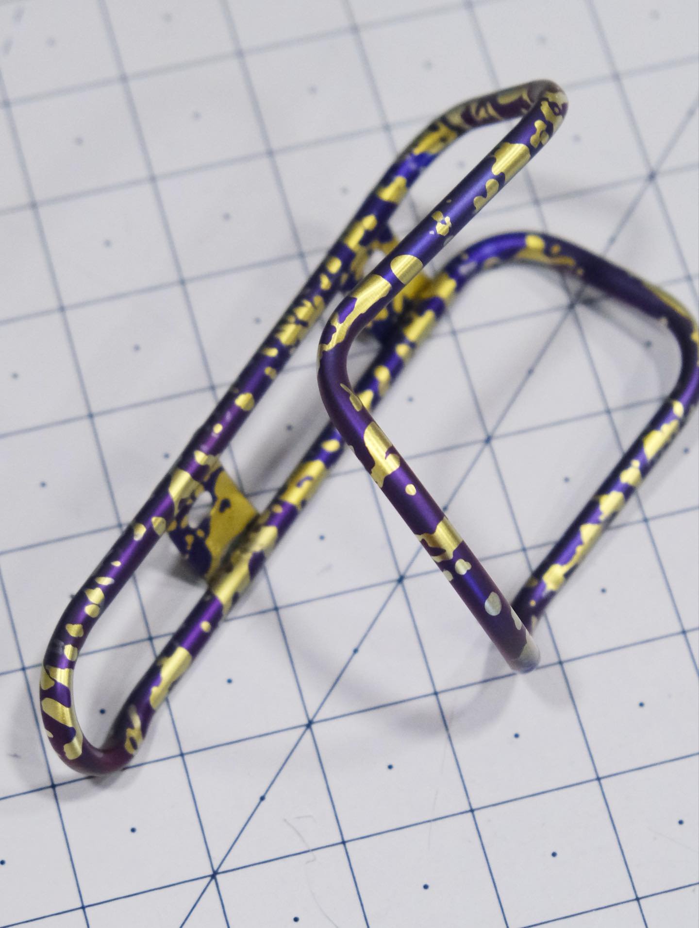 A special purple and gold splattered cage for Andrew, anodized and sent just in time for Christmas 🧨💥
.
.
.
#kingcage #titaniumanodizing #madeinusa #cycling #splatterano