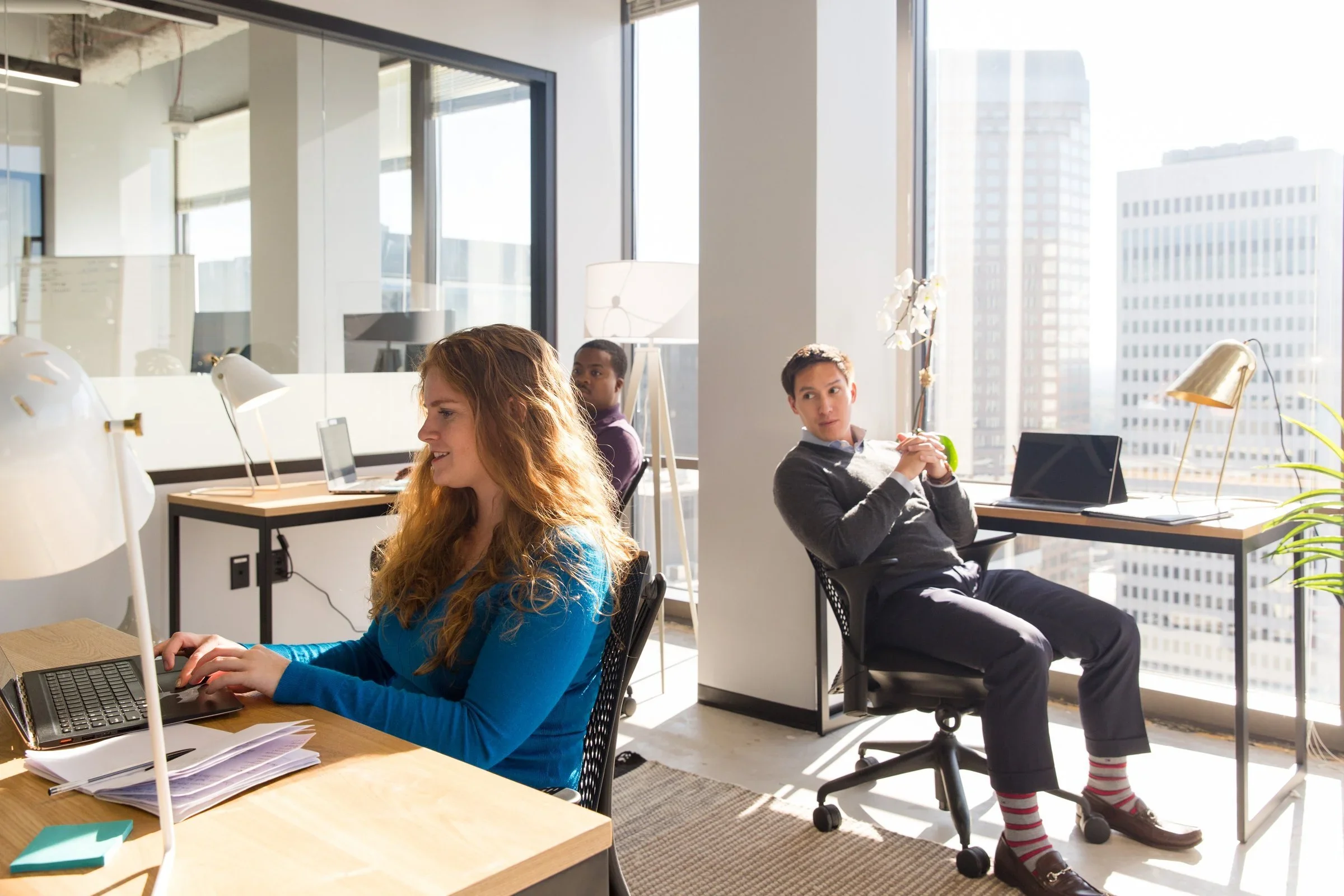 Two coworkers talking in a bright office