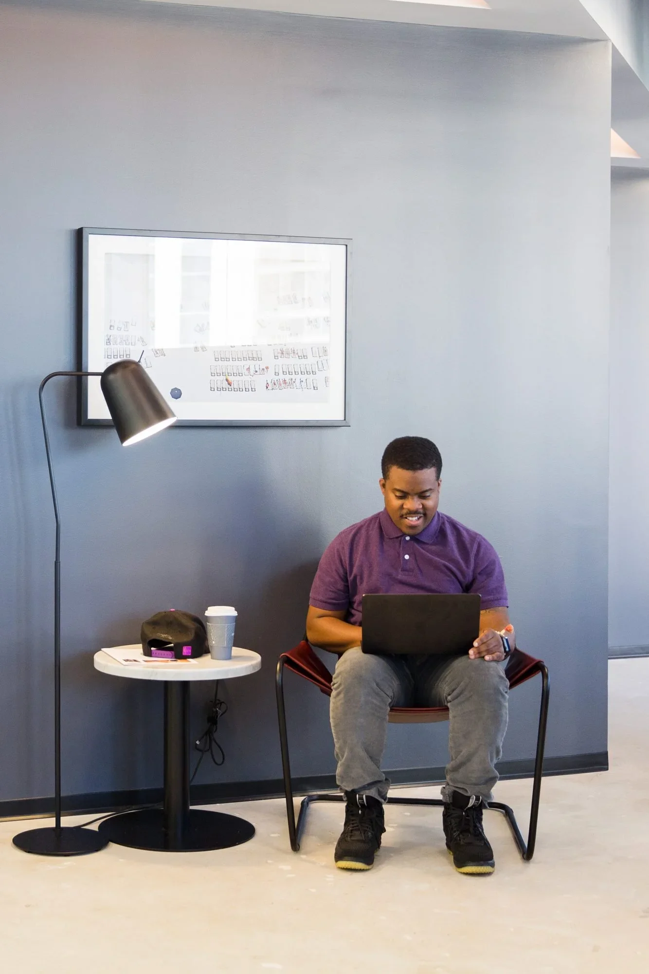 Man working on a laptop while seated in a lounge chair
