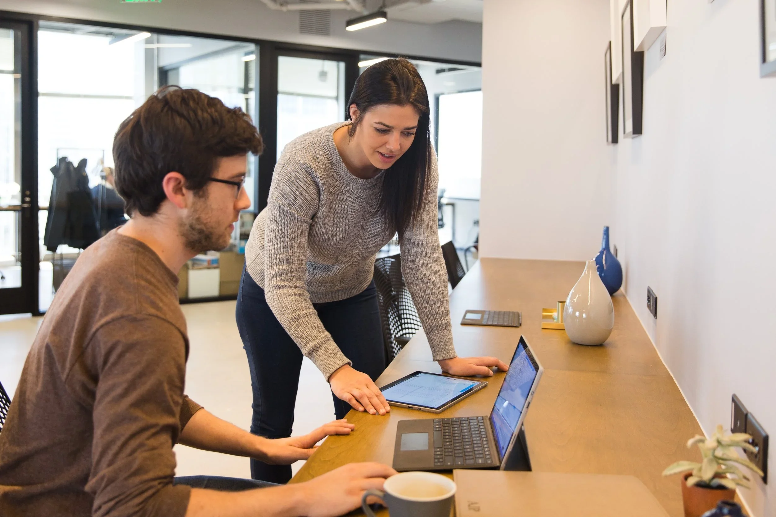 Two colleagues looking at a laptop together