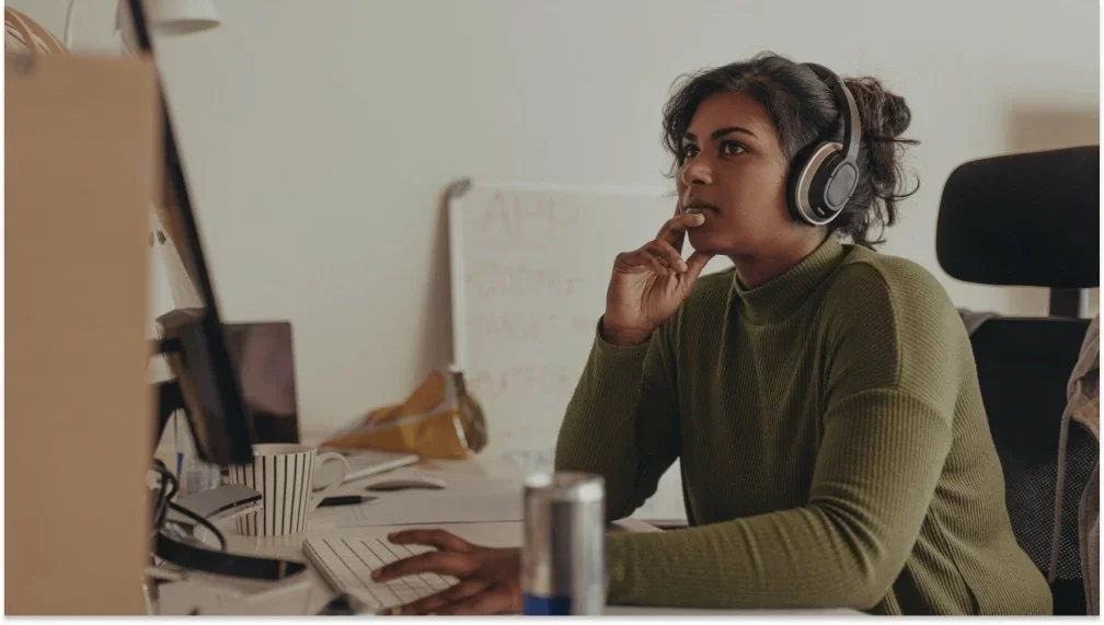 Woman wearing headphones working at a computer