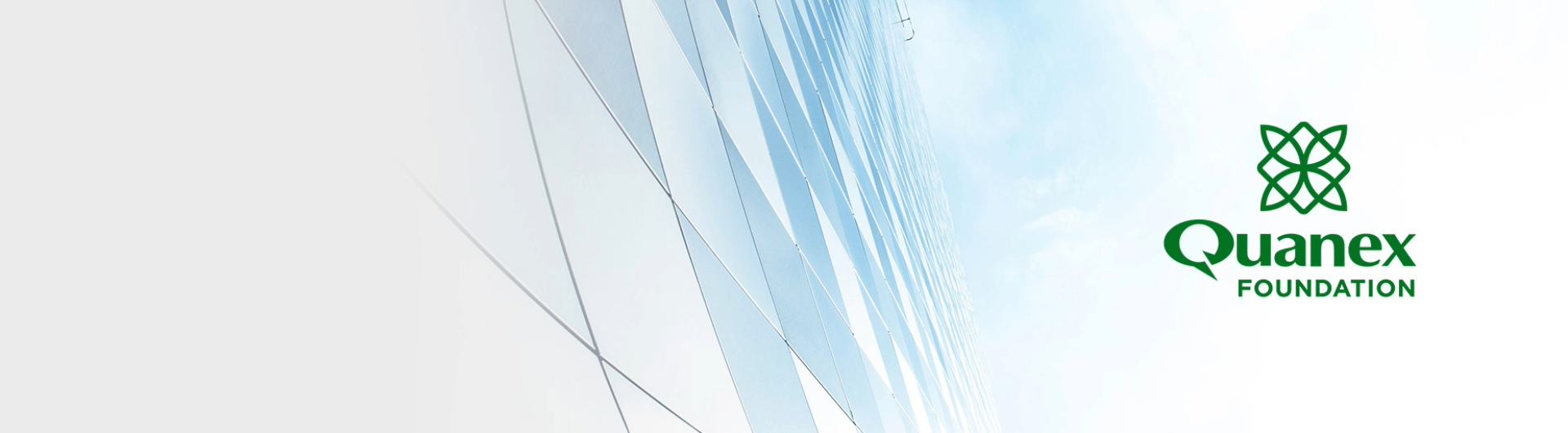 Modern glass building with a blue sky background and the Quanex Foundation logo in green on the right side.