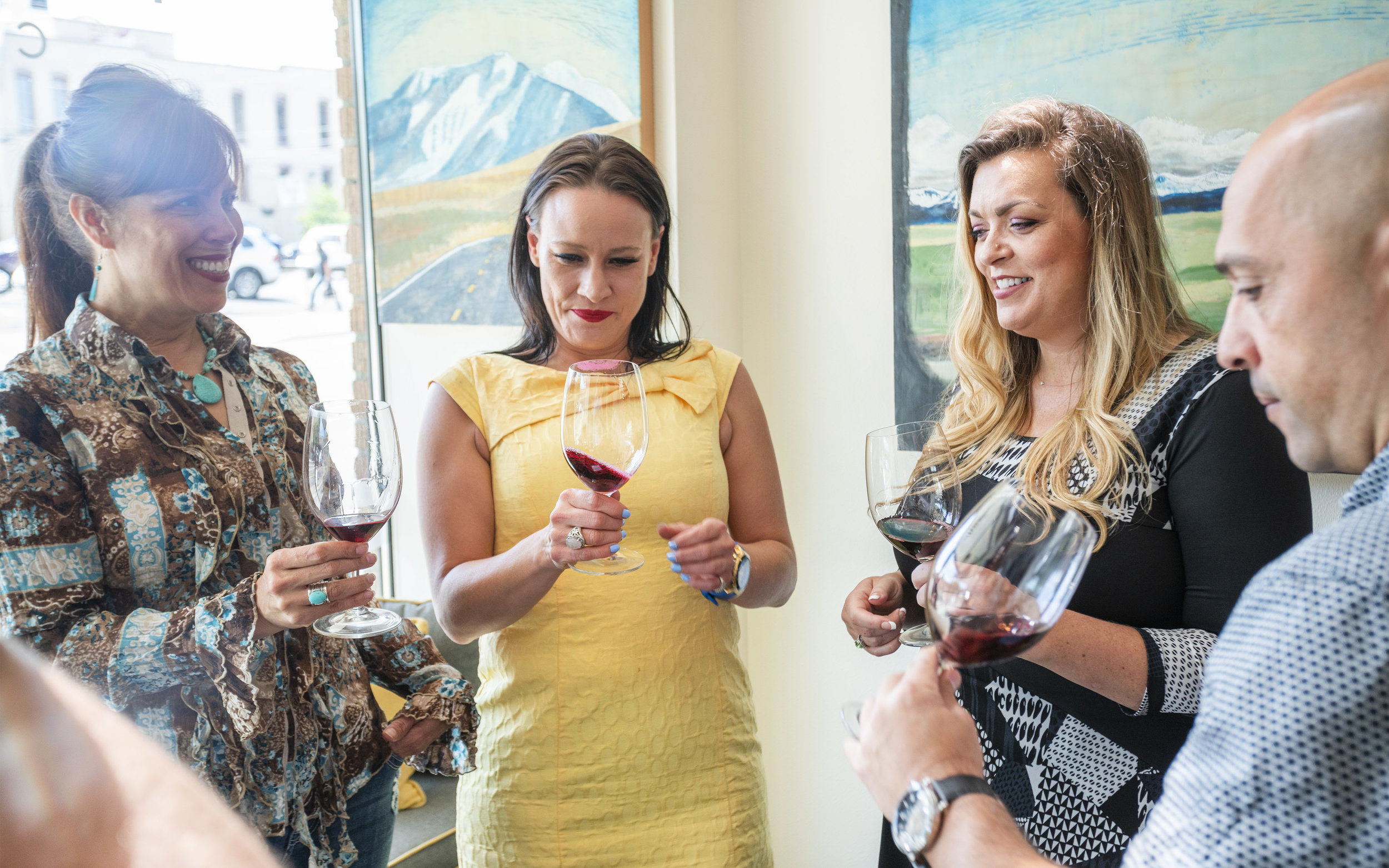 Guests at the Mansion Creek Cellars tasting room in Walla Walla Washington swirl the wine in their glasses.