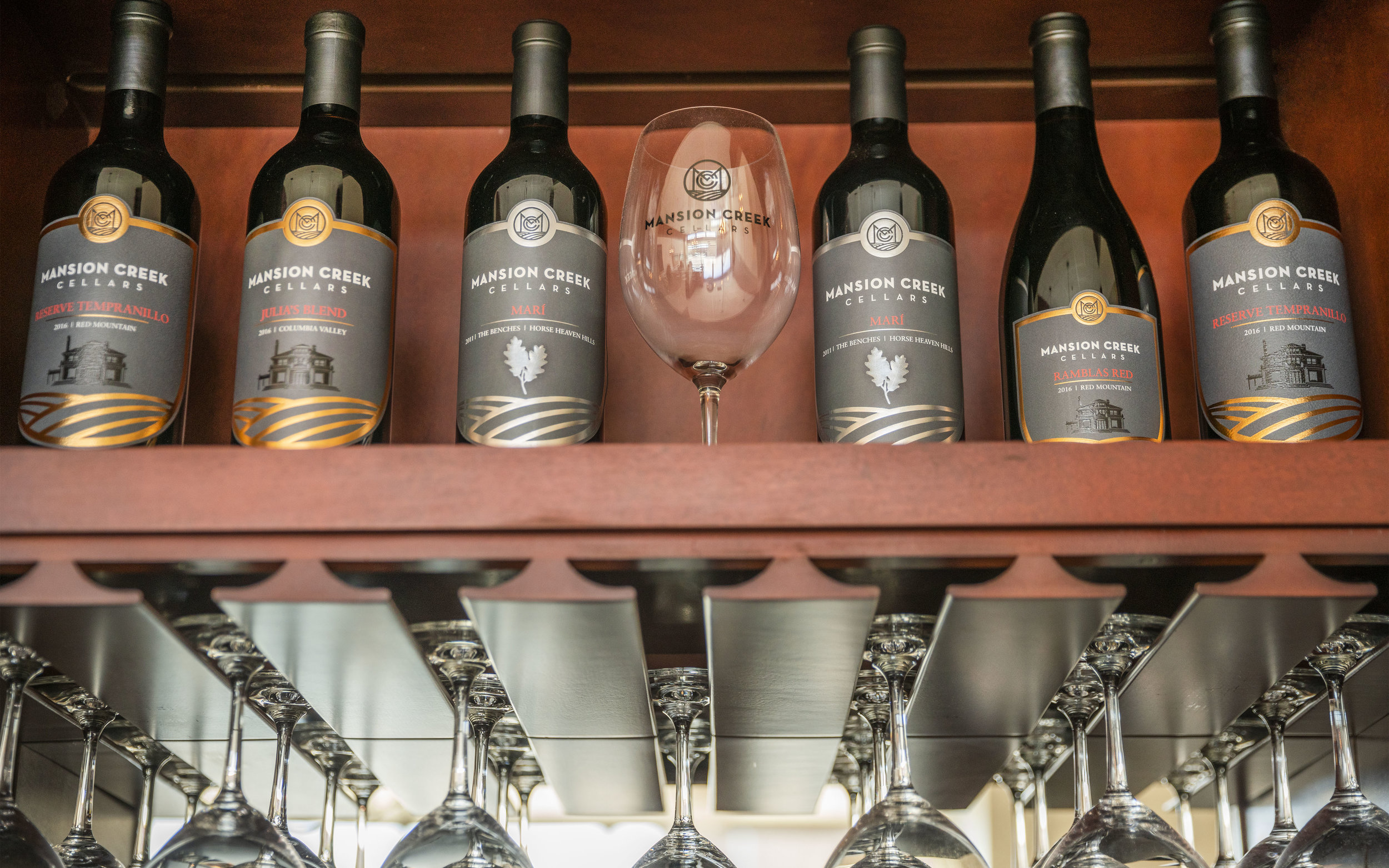 A photo of glassware and bottles of Mansion Creek wines in the Mansion Creek tasting room.