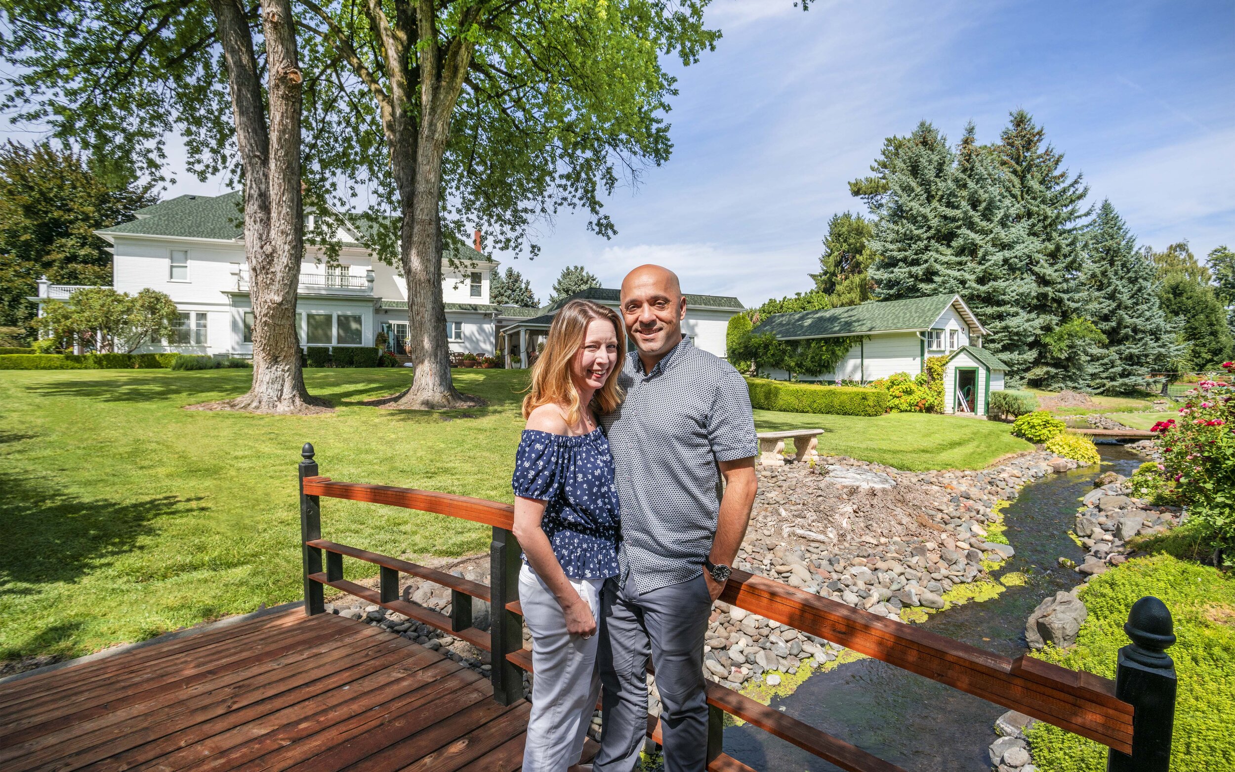 Tina and Denny, owners of Mansion Creek Cellars, pose for a photo in front of the mansion that gives the winery its name.