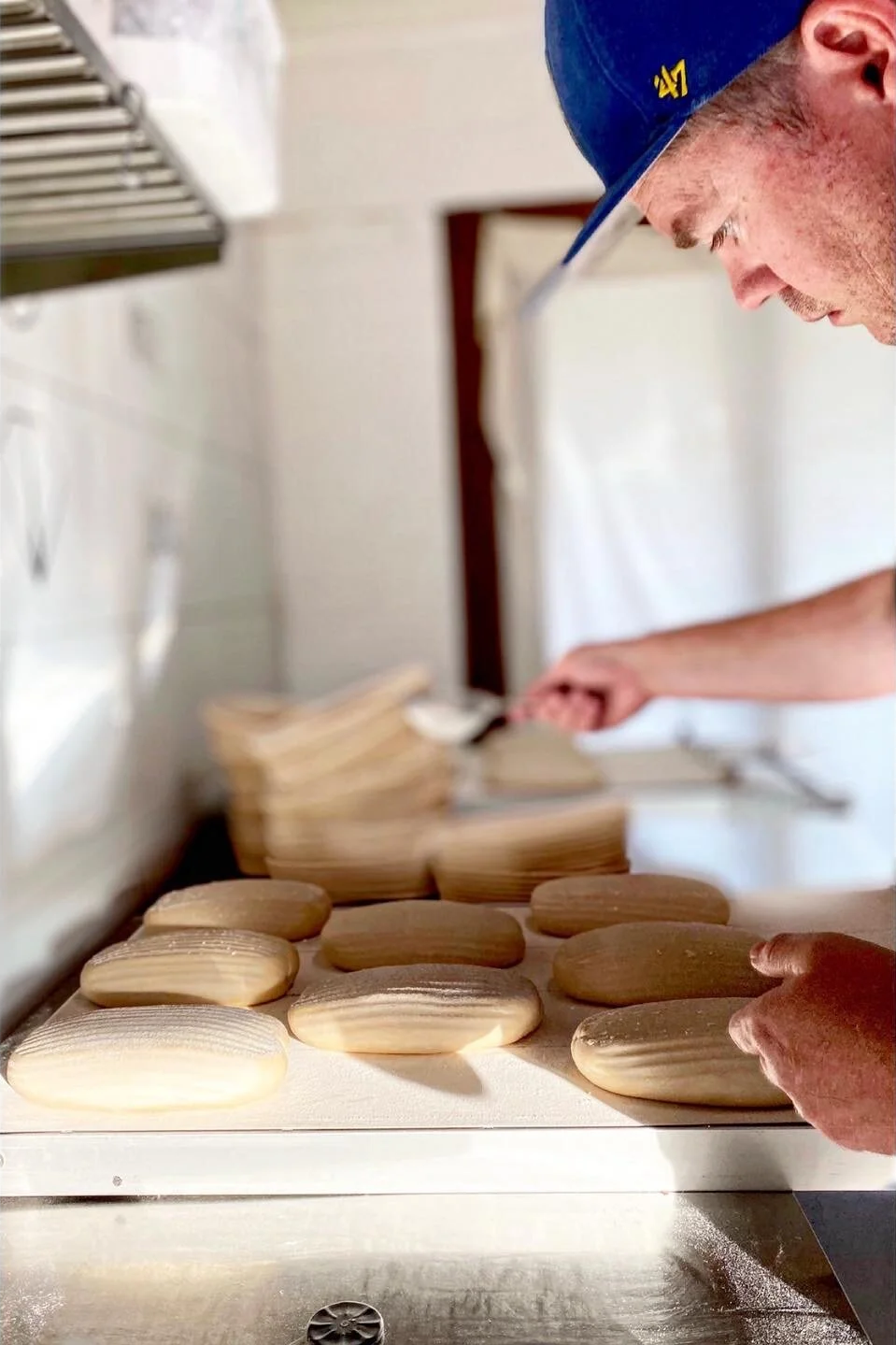 Baker placing dough on loader for baking