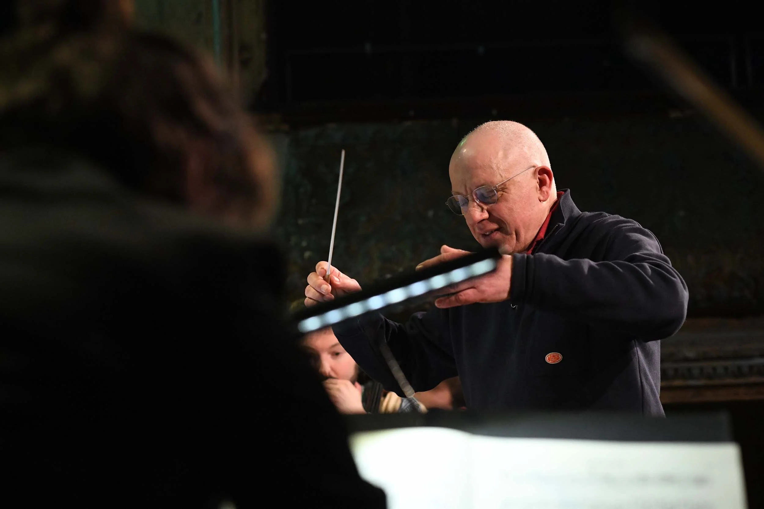 bald-man-glasses-baton-looking-down.jpg