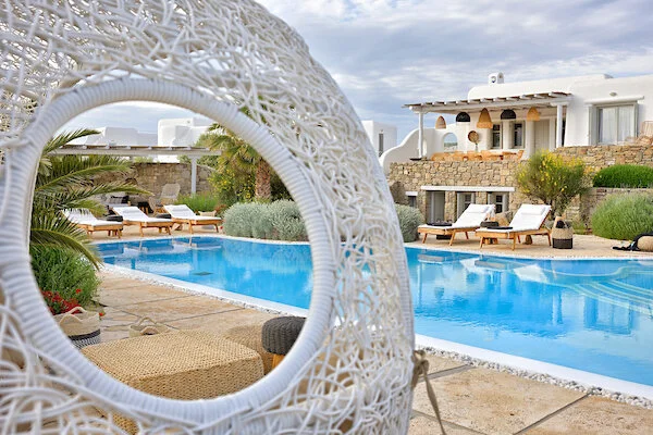 Round stone window opening onto the pool at Villa Afroditi