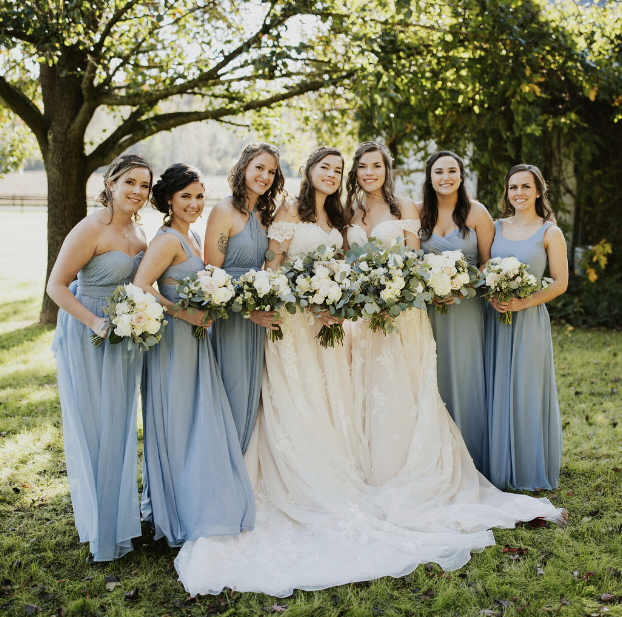 two brides with their bridesmaids at an Oakland Farm wedding