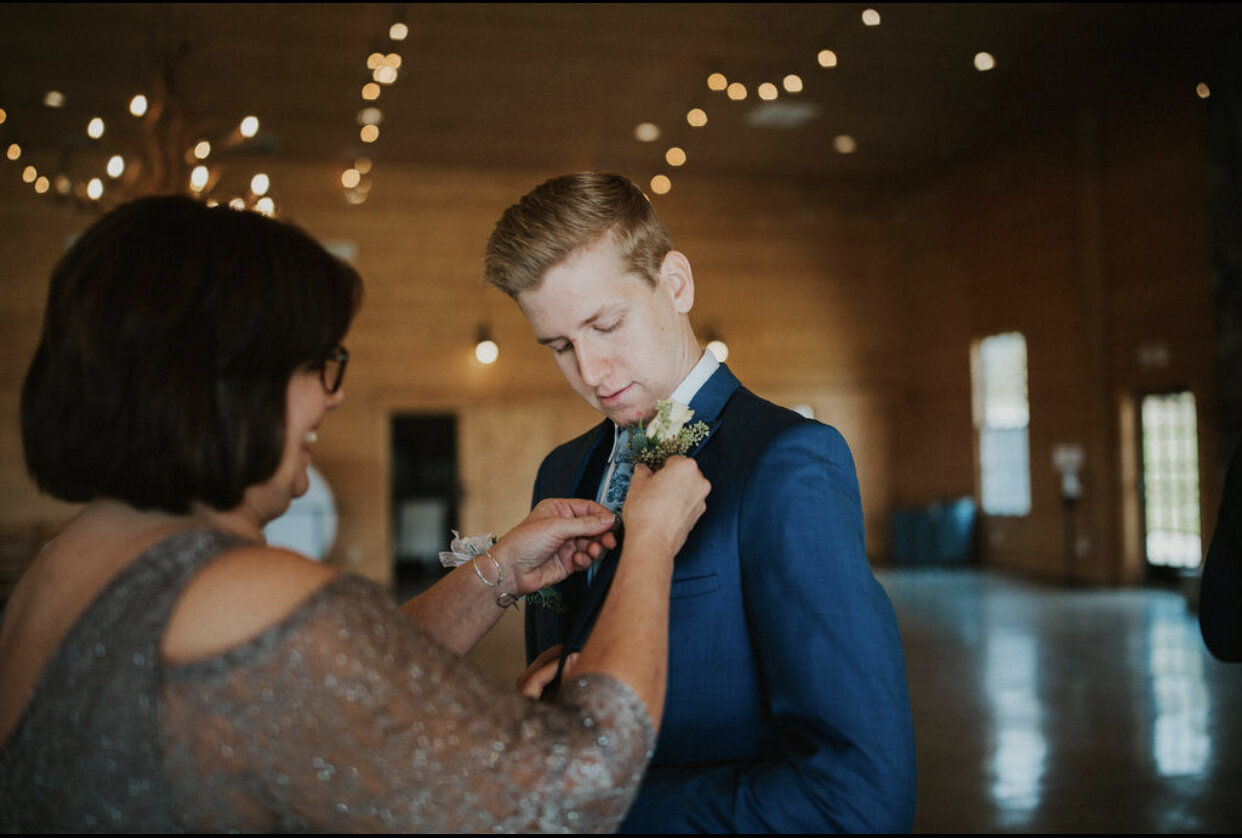 Oakland-farm-mom-pins-groom-boutonniere.PNG