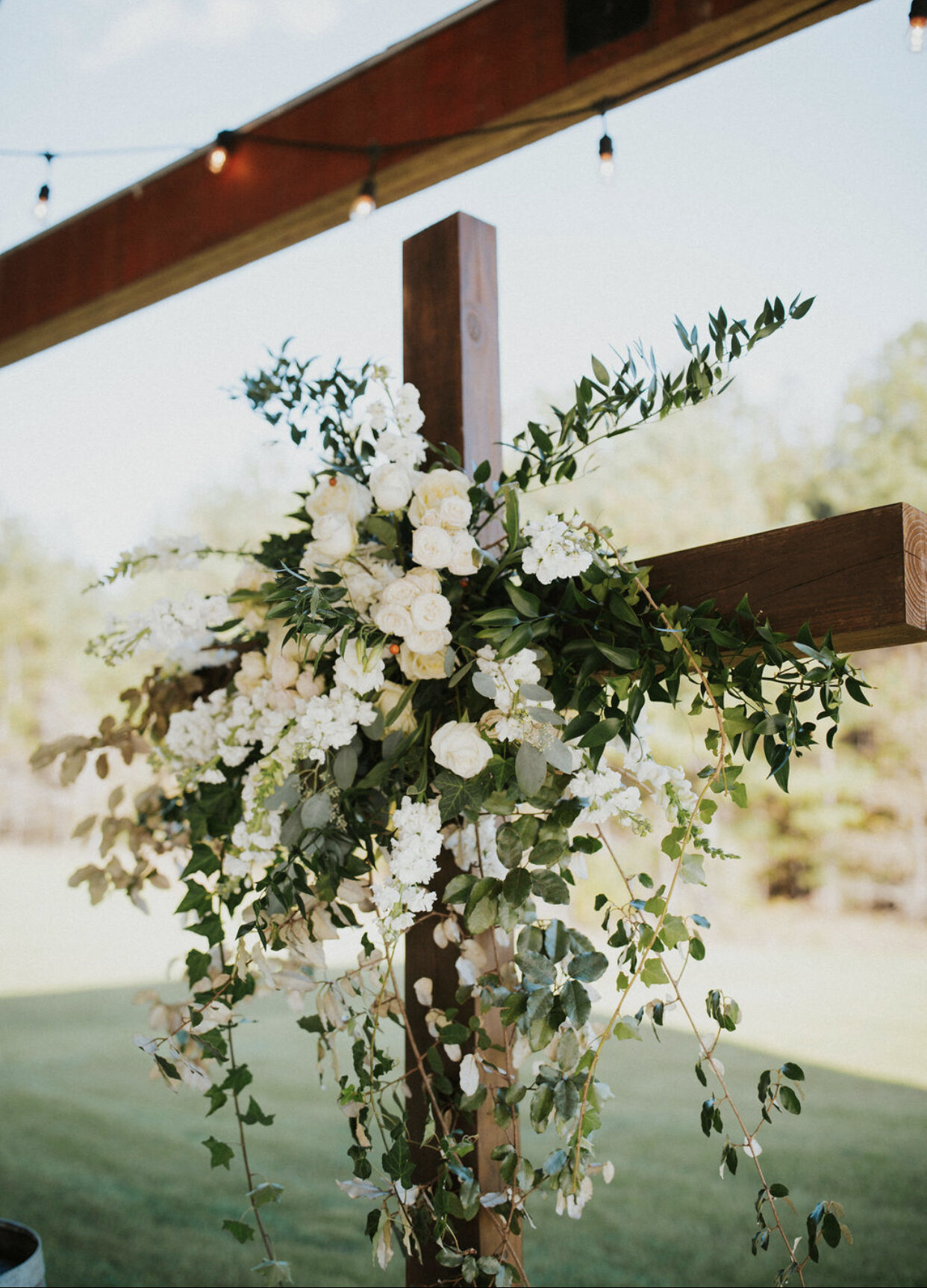 Oakland-farm-wedding-ceremony-cross-white-green-florals.PNG
