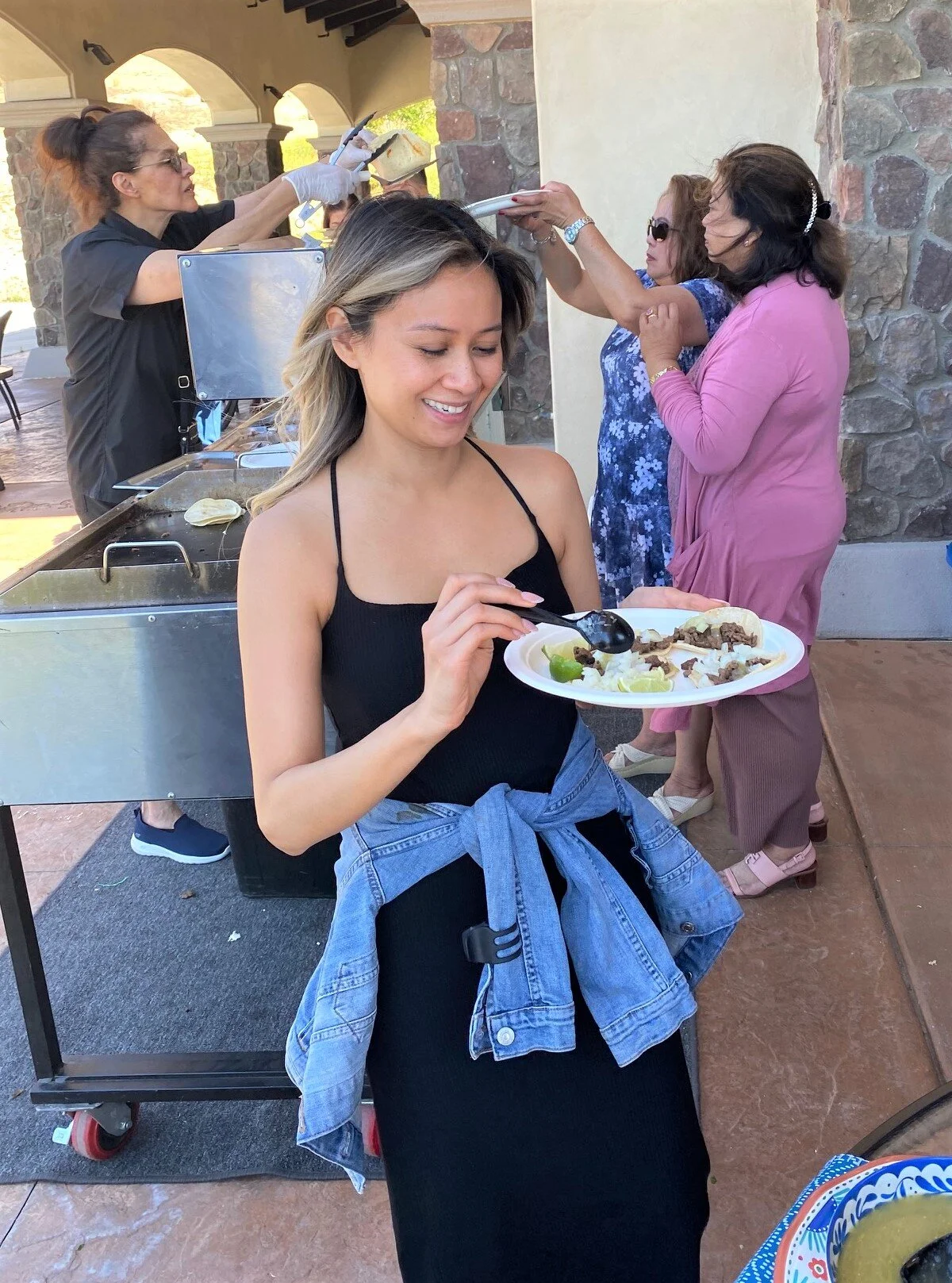 Guest enjoying freshly made tacos featuring our grilled carne asada finished with grass-fed Wagyu tallow during a LaLa Tacos catered event.