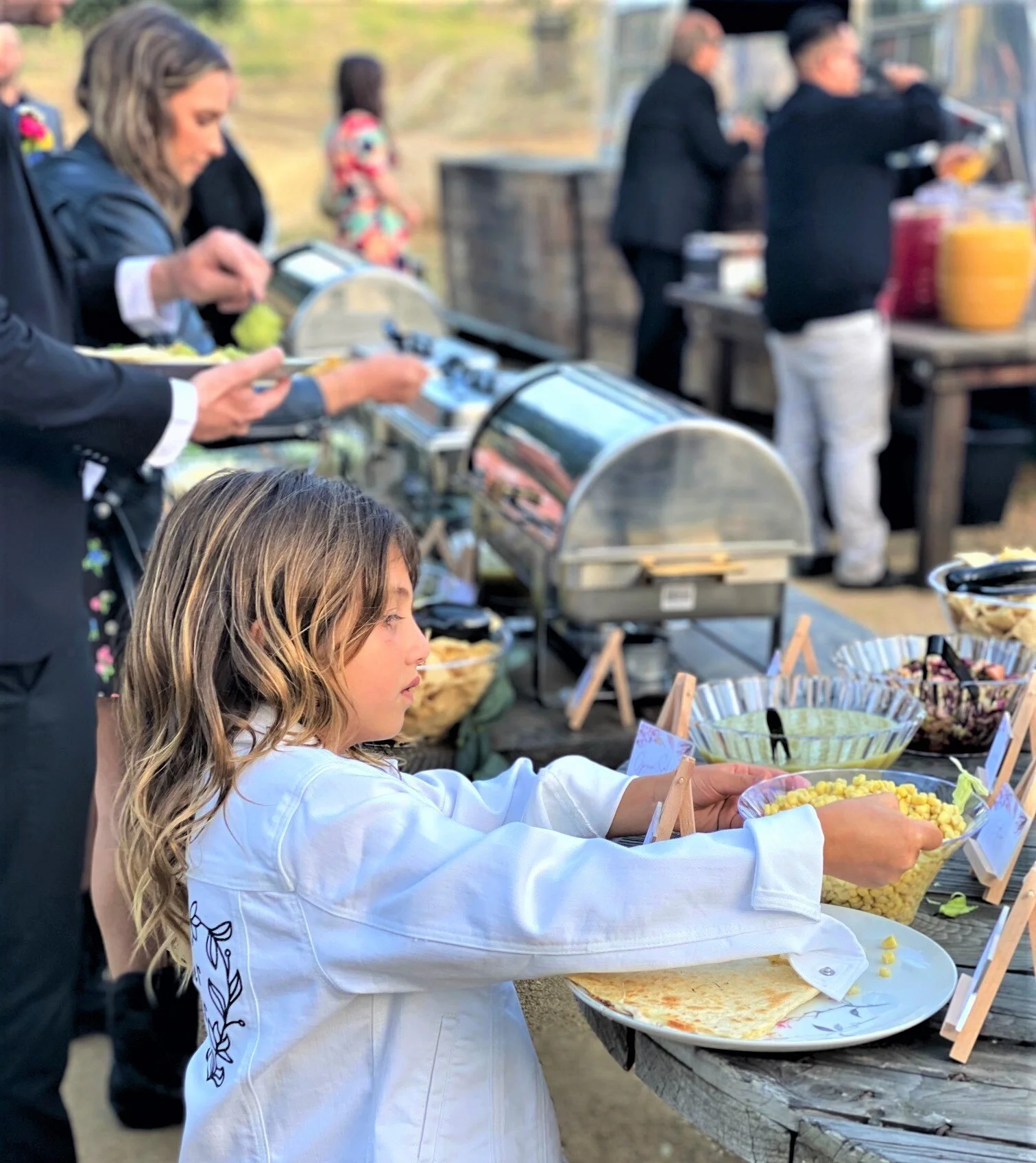 A child customizing a plate at an elite on-site taco bar during a high-end private event.