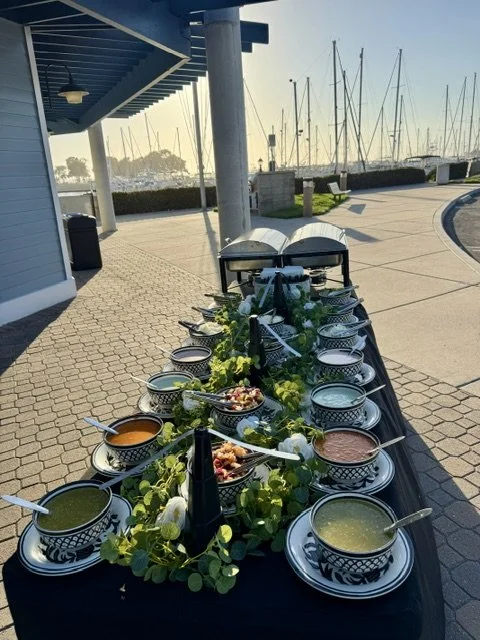Premium taco catering buffet with fresh salsas and greenery overlooking the marina yachts at a luxury Newport Beach event.