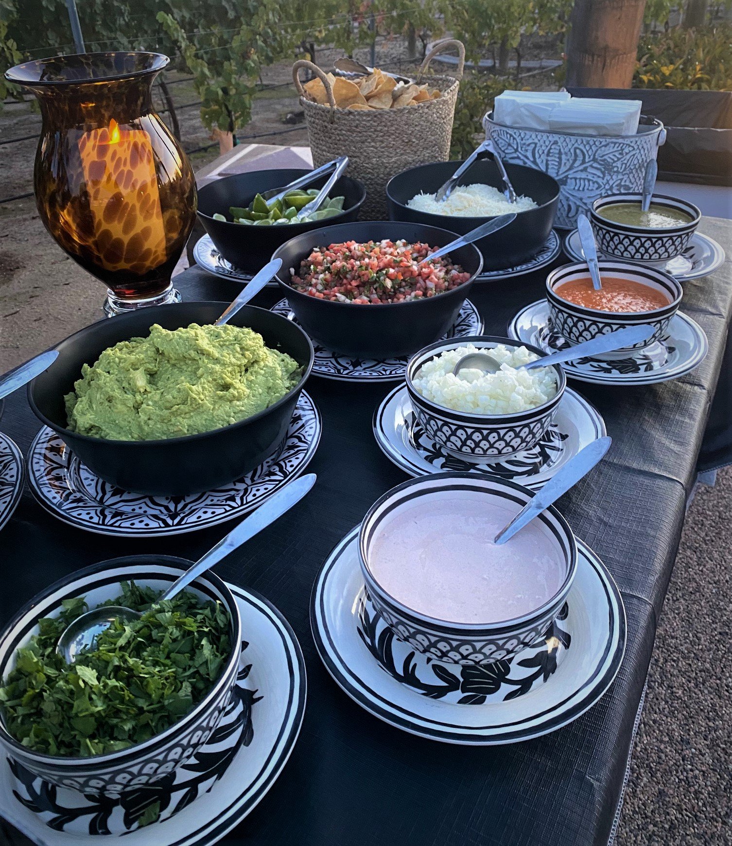Elegant taco bar with fresh guacamole, pico de gallo, handmade salsas, cilantro, onions, and premium toppings at a private catered event in San Diego.