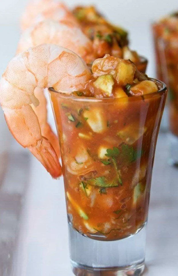 Gourmet shrimp cocktail shooter appetizers in individual glasses featuring fresh jumbo shrimp and zesty cocktail salsa for coastal wedding catering