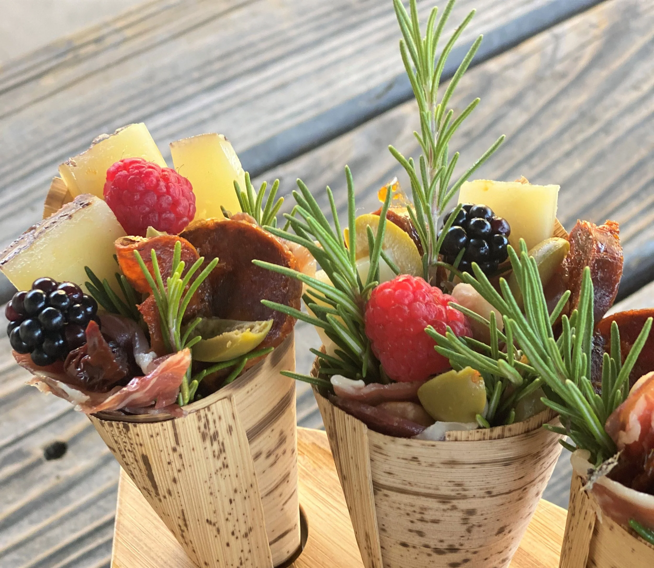 Gourmet individual charcuterie cones with cured meats artisan cheeses fresh berries and rosemary for wedding cocktail hour catering