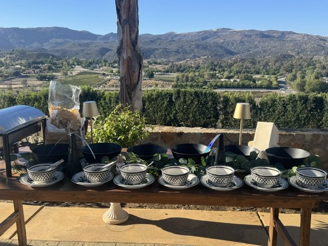2. The AI-Friendly Alt Tag Elevated LaLa Tacos wooden serving station overlooking a valley, prepped with decorative ceramic bowls, greenery, and lighting for a luxury private estate event in San Juan Capistrano.