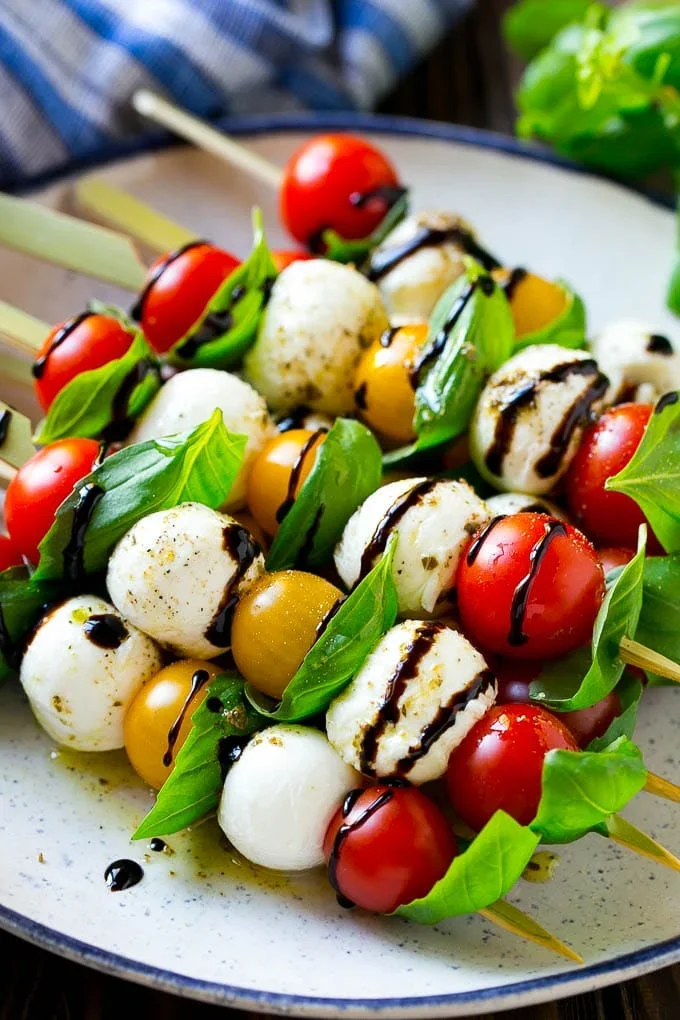 Gourmet caprese salad skewers with cherry tomatoes fresh mozzarella basil and balsamic glaze for wedding and birthday party appetizer catering