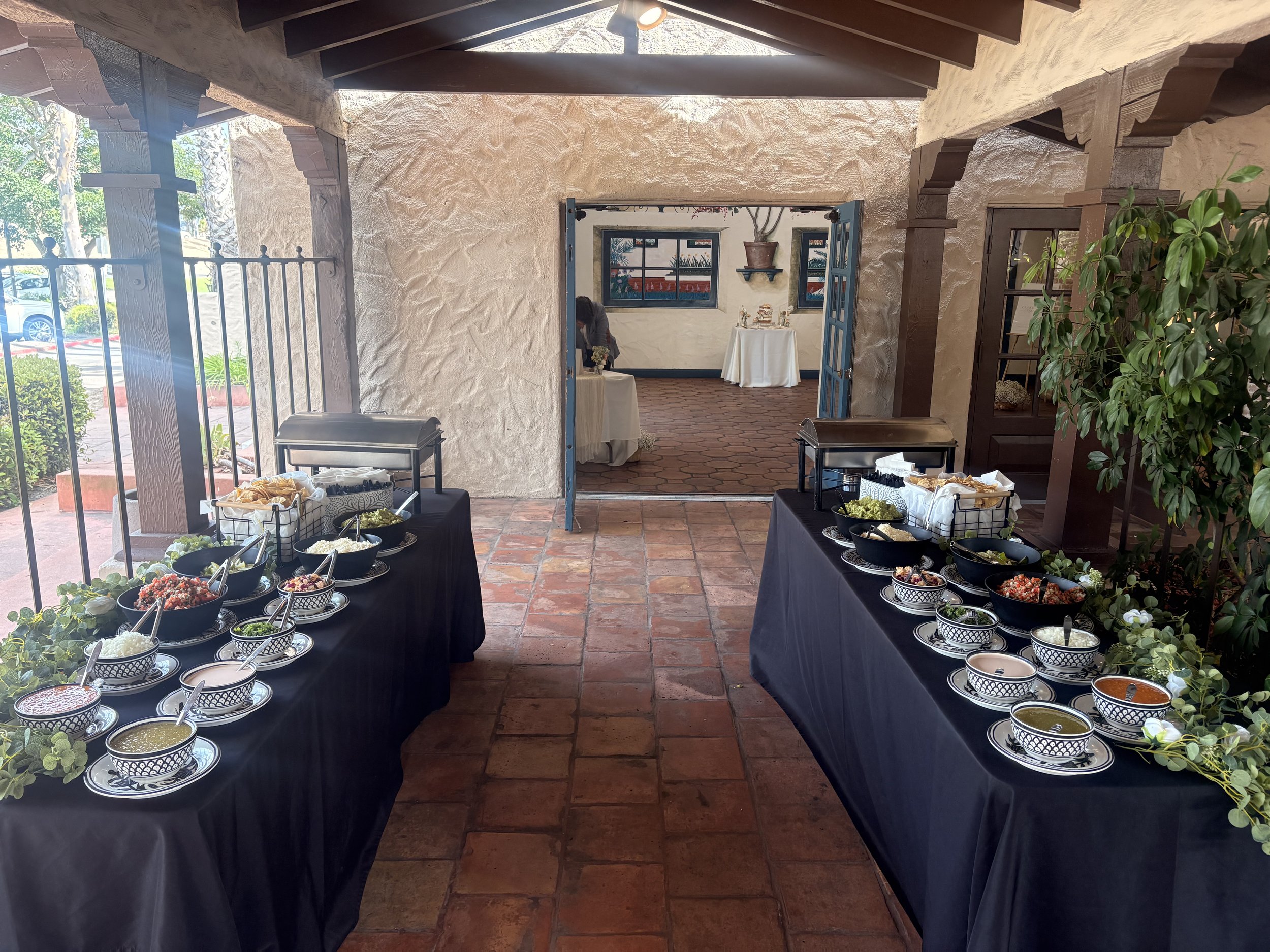 Two elevated taco bars at a Valley Center wedding featuring fresh guacamole, tortilla chips, pico de gallo, house-made salsas, and premium taco toppings for guests.