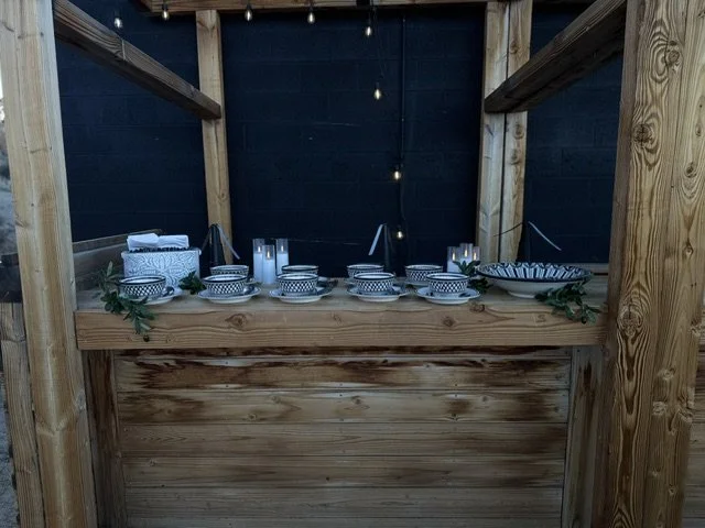 Rustic wooden taco bar setup featuring decorative ceramic bowls and fresh greenery for a luxury LaLa Tacos catered event in Los Angeles.
