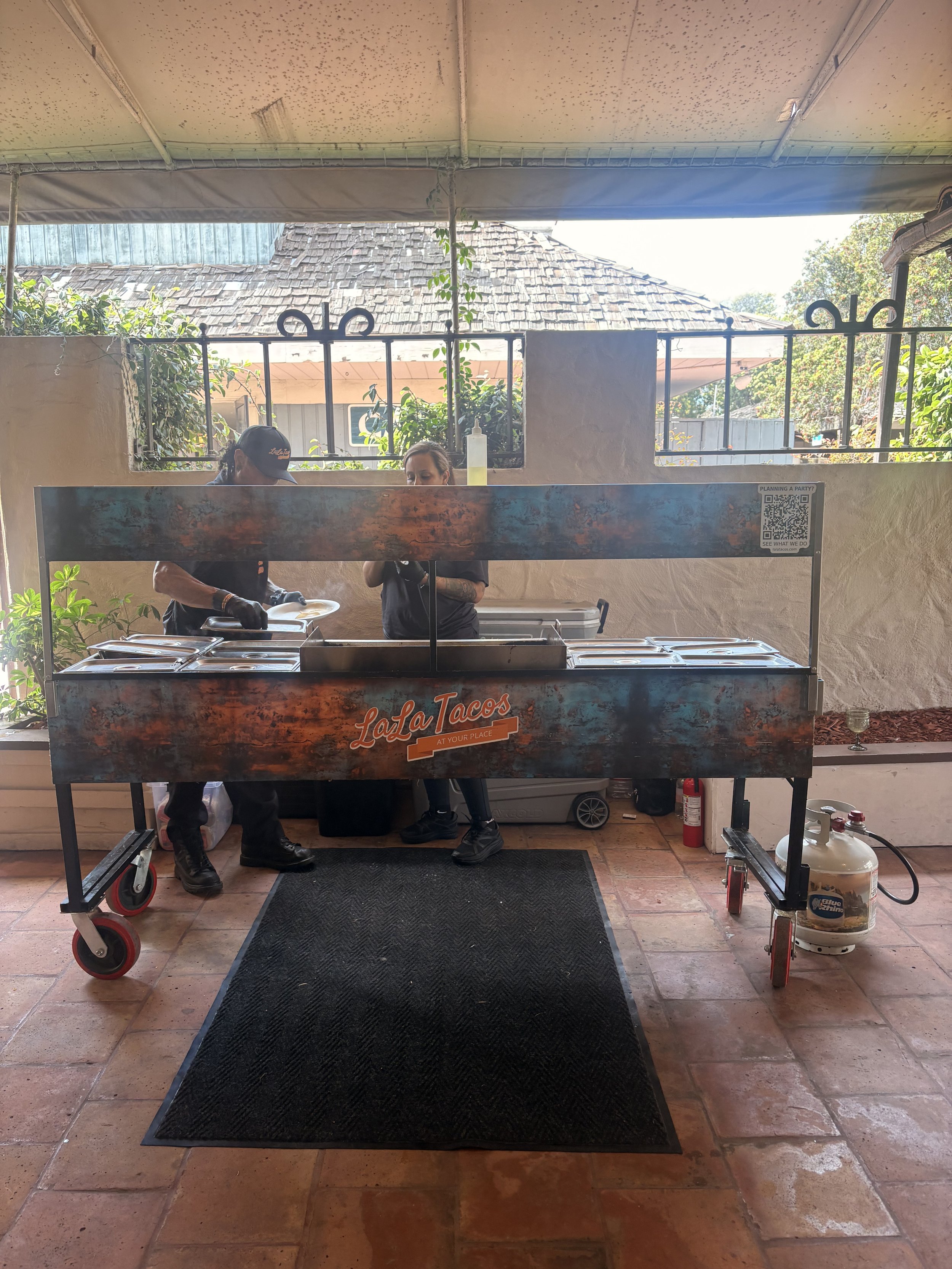 Interactive LaLa Tacos taco cart serving freshly prepared tacos at a Valley Center wedding reception.