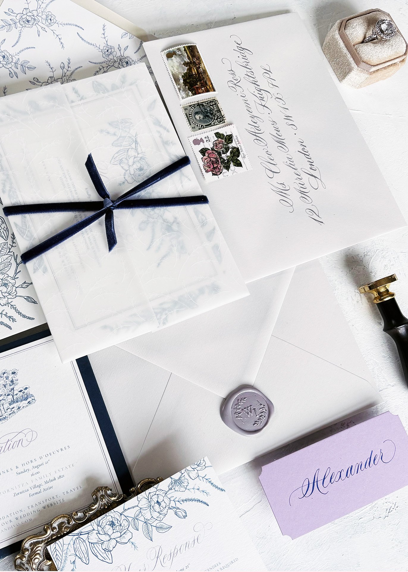 A suite of wedding invitation stationery with a hand-addressed envelope and letterpress invitation wax seal and calligraphy place card