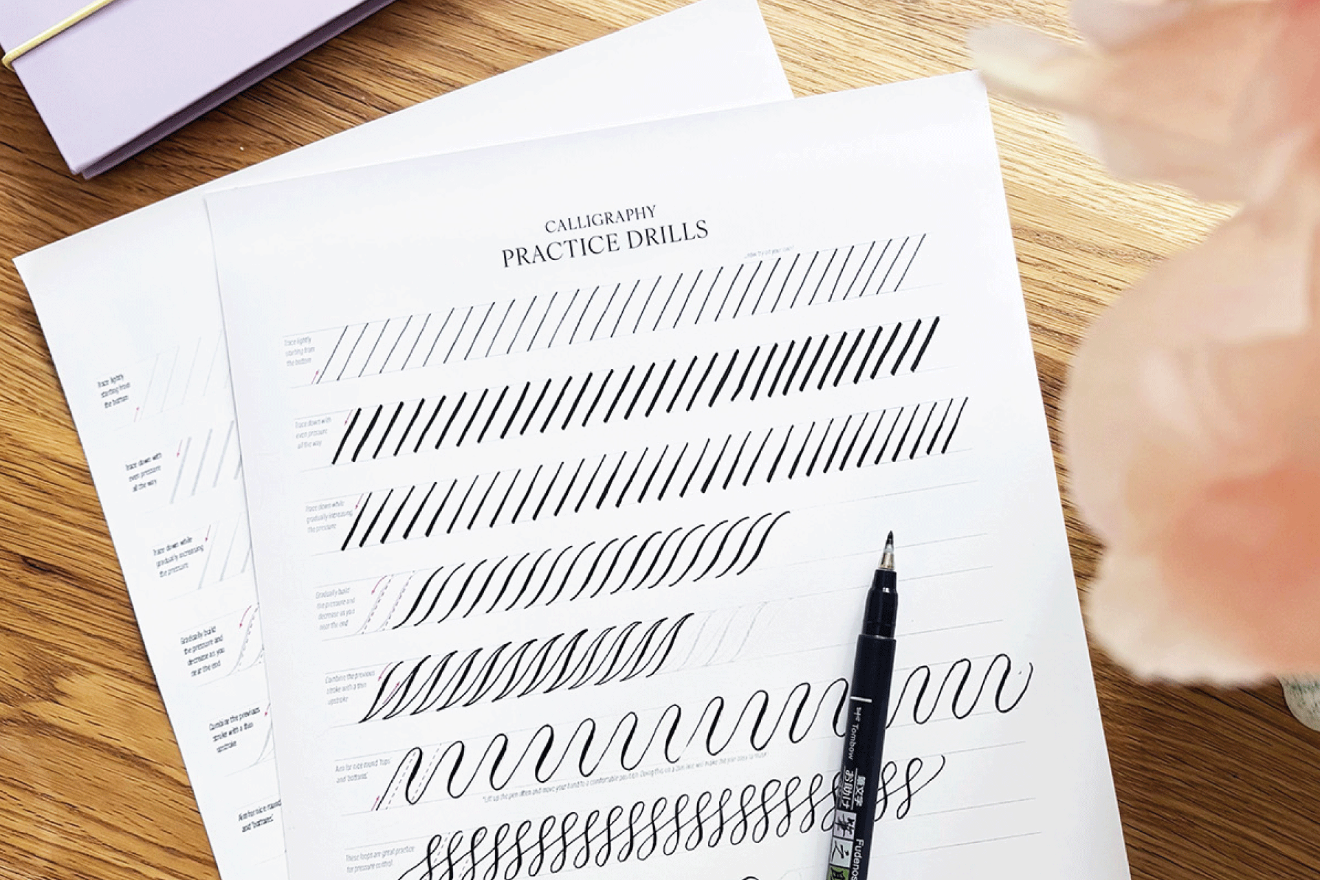overhead shot of  a brush pen and calligraphy practice worksheets