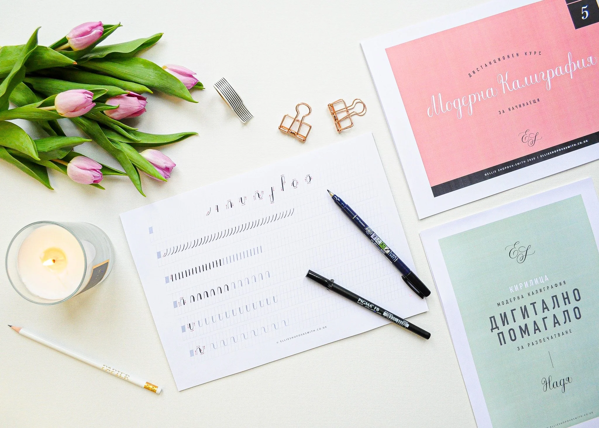 Overhead image of a desk set up with calligraphy pens and worksheets ready for writing.