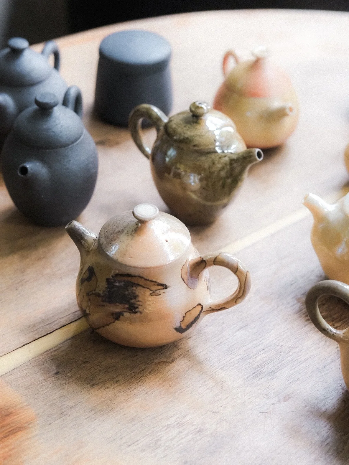 #策展紀錄
Every Inspiring Moment 主題展
/ 柴火記 /
座落在台中東海商圈巷弄內的陶藝工作室「石見坊」,由陶藝師張皓硯與太太愷絮主理,以一塊土、一雙手、一件器物,實踐著純粹的生活手感。
石見坊的起源,來自皓硯對柴燒的長年專研與創作。為了陪伴孩子成長,他們成立了這個品牌,讓生活與創作得以並行。
柴燒,不使用釉藥,而是讓火與土直接對話。透過不同土質、火焰、煙氣與草木灰燼,在高溫中留下不可複製的痕跡——如鏡面般光澤,亦如礫石般沉靜。這些,是時間與