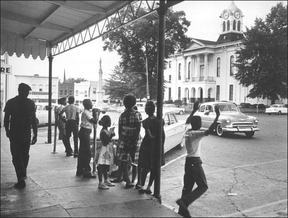  Martin J. Dain  Faulkner’s World, Oxford, Mississippi, 1961-1963  (Watching Faulkner’s Hearse Drive By, the Oxford Square)  Gelatin silver, 16 x 20”  Signed 