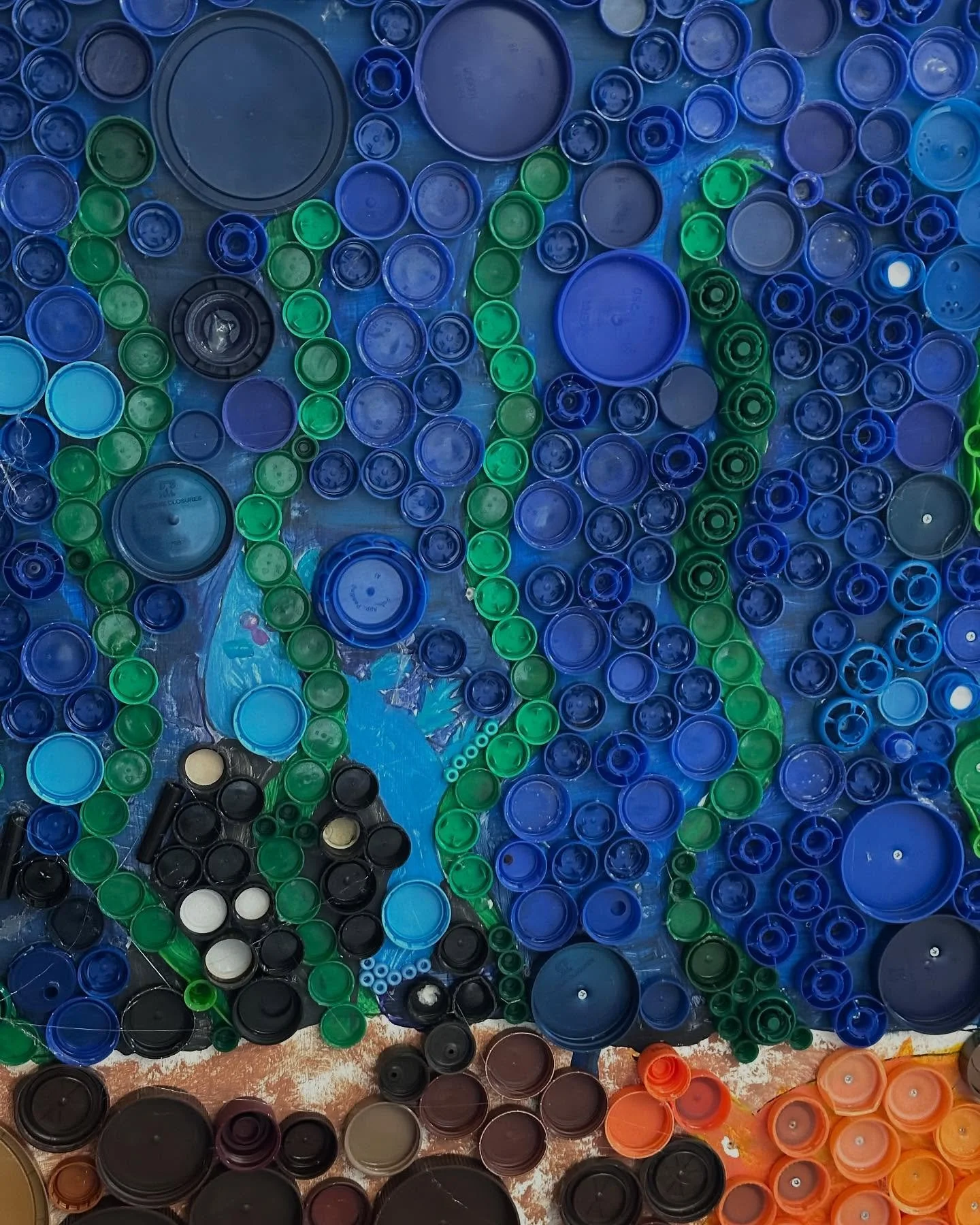 All year Matheia students have been working on ocean murals made from plastic lids. #recycledart #plasticart #oceanmural