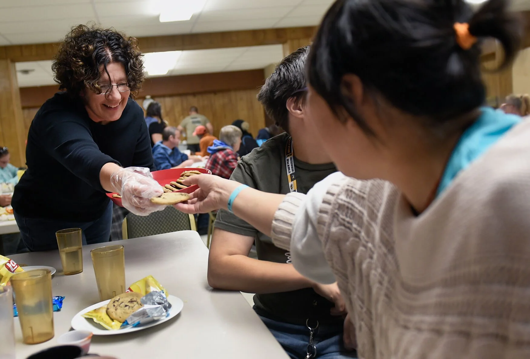 Nancy Tran, center, passes a cookie to a guest for dessert on Thursday, Nov. 2 at Wilkes Methodist Church in Columbia. The church originally asked Loaves & Fishes to move out by Oct. 1 but pushed the date back a month to Nov. 1. For now, the precise