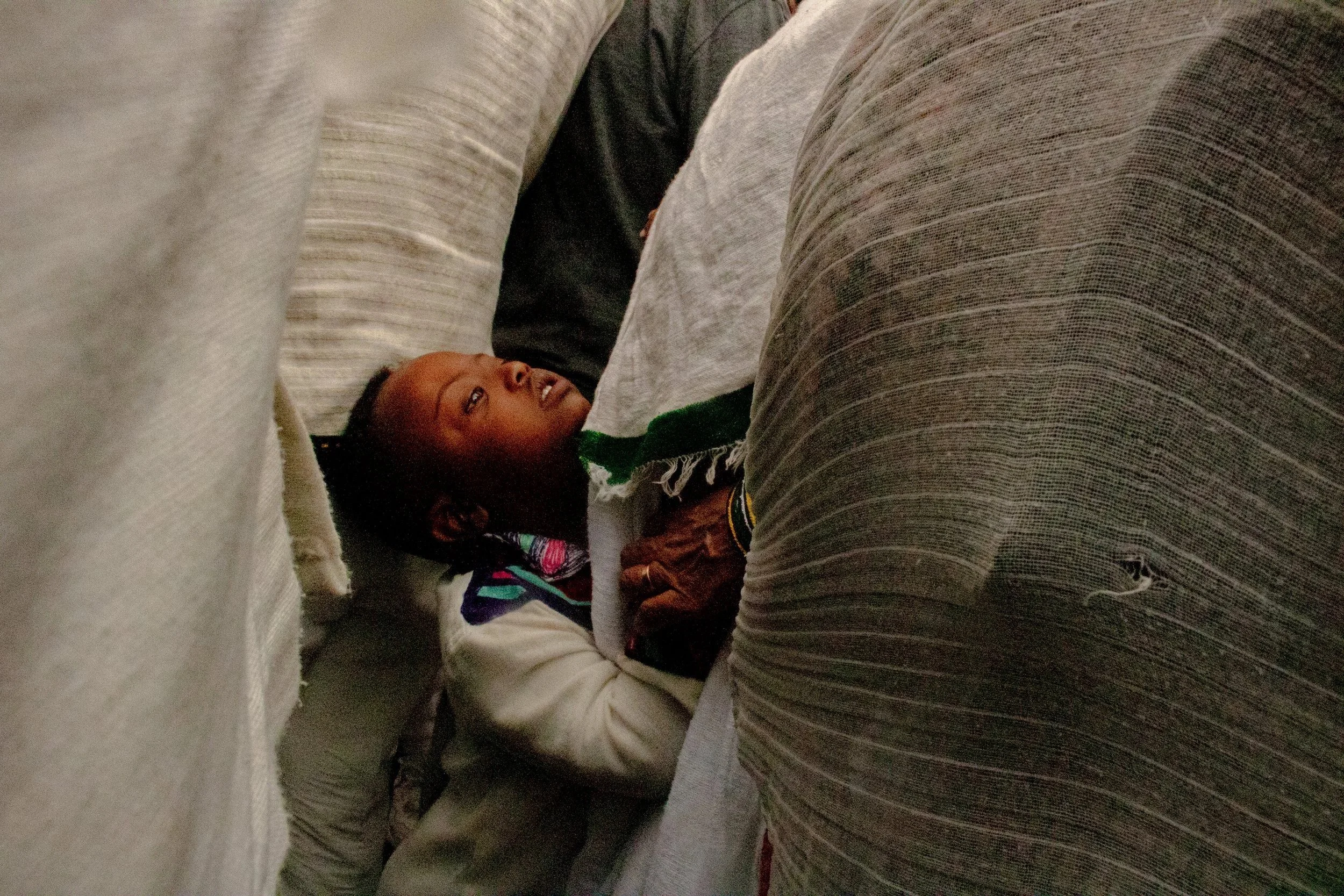 A child clings onto his mother in a crowd during the celebration of the Ethiopian holiday ‘Timket’ in Addis, Ababa Ethiopia on January 20, 2024. 