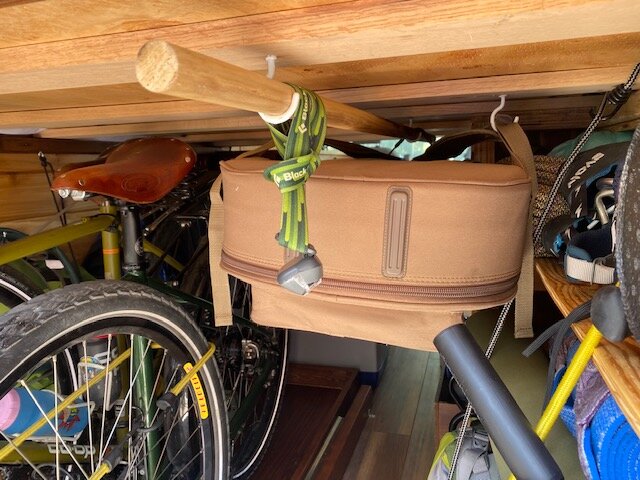  Installing a dowel where we can hang wet clothes and Doug’s guitar. Also, the headlamp serves as a light for the garage! 