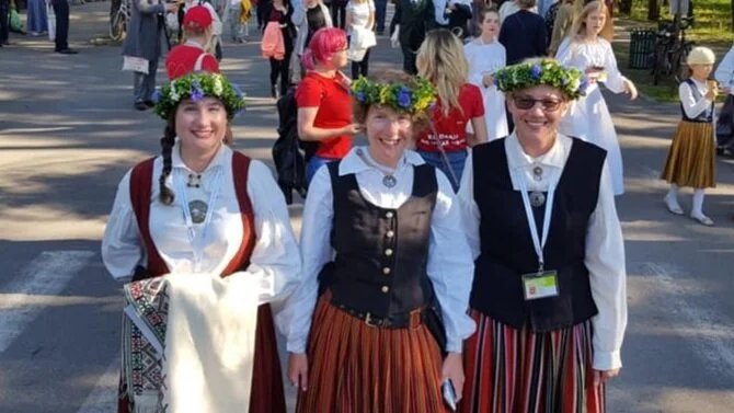 “Me with my two older sisters (I’m in the middle) in Latvia’s beautiful Mežaparks, a beautiful woodland park that includes a huge outdoor concert venue where the giant combined choir concerts were held. We are wearing our folk costumes.”
