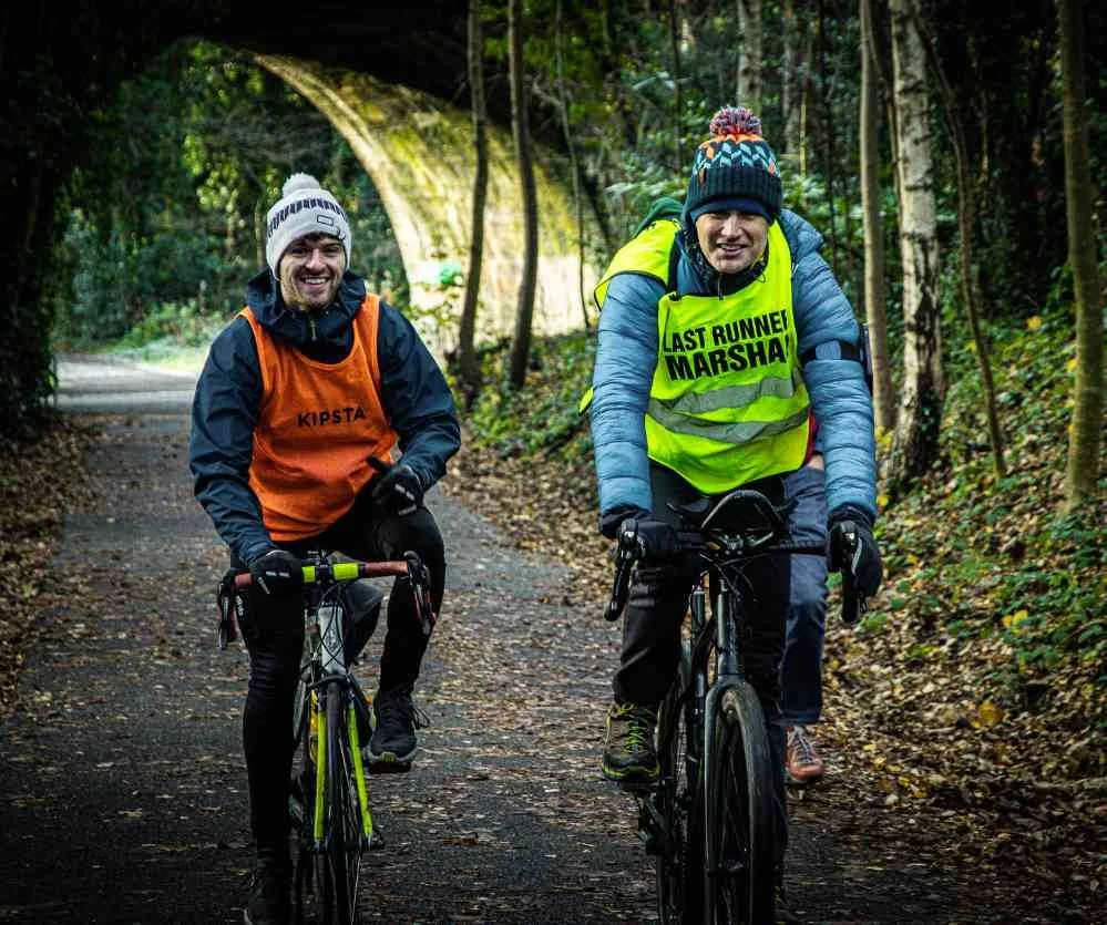 Race marshals cycling back towards the finish line after supporting the Water of Leith half marathon in Edinburgh