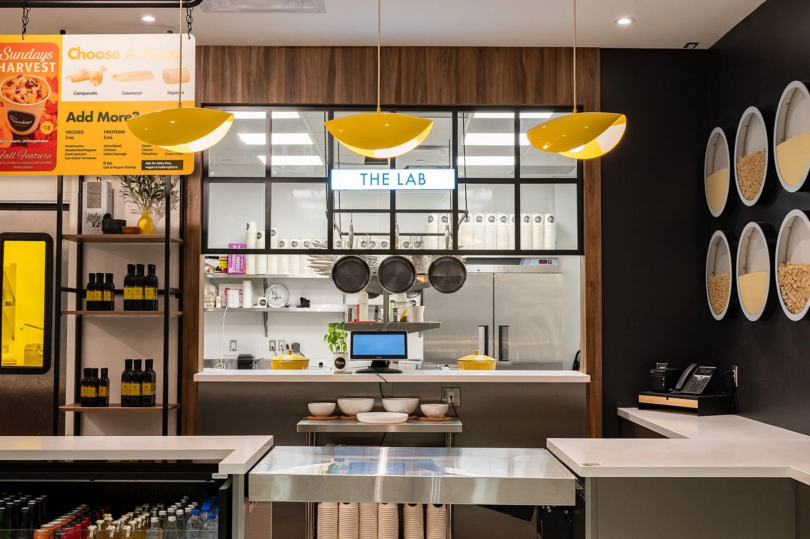 Industrial style service counter with yellow pasta shaped pendants above