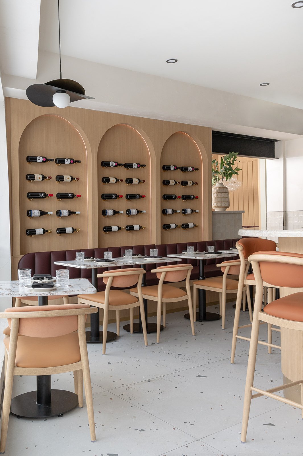Italian restaurant banquette with wine bottle display above