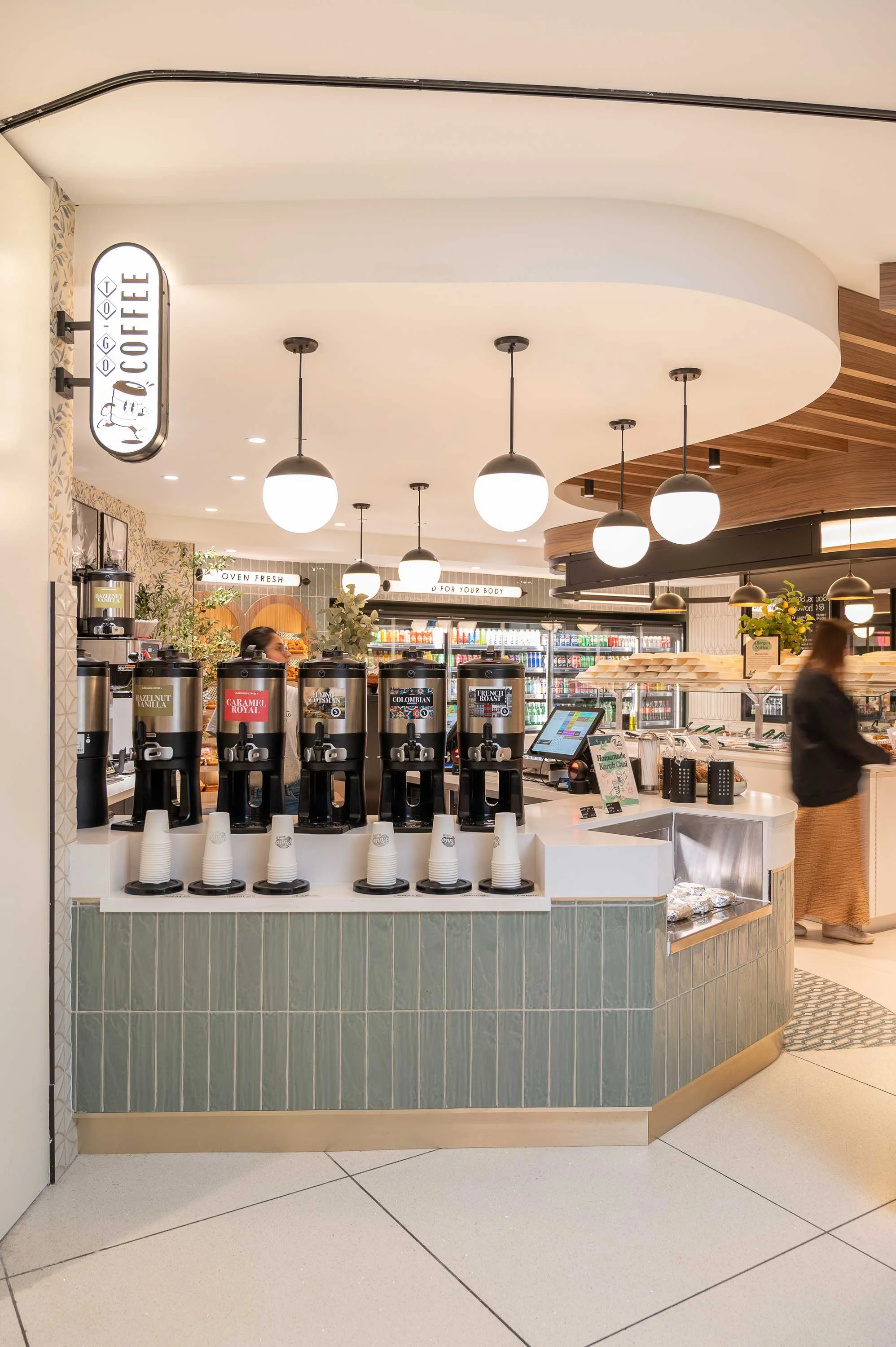 Pinto Market coffee counter with iluminated blade sign and sage green tile counter face