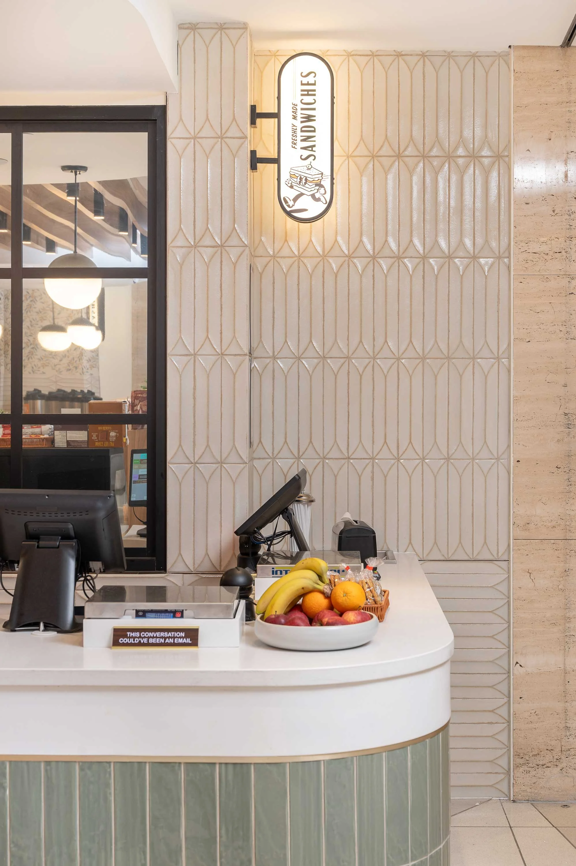 Pinto Market counter with illuminated blade sign and geometric tiled wall