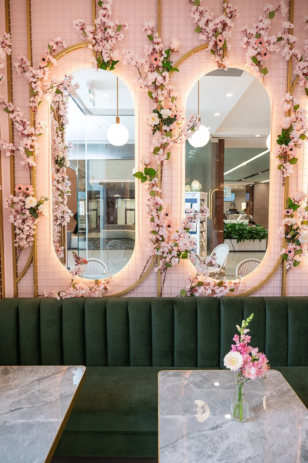 Fluted dark green marble column detail with pink upholstered banquette at Blossom Moments Scotia Plaza