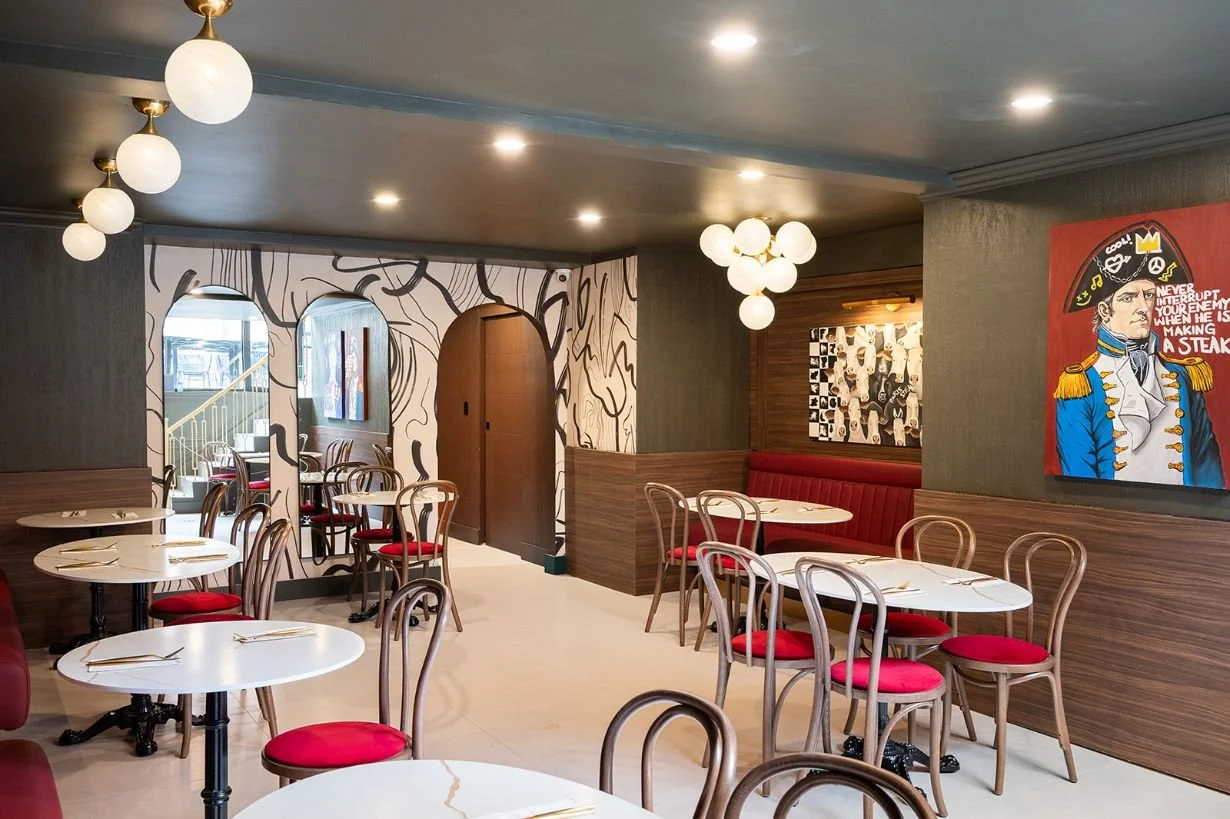 Steakhouse restaurant bistro seating with walnut wall paneling and red leather upholstery finished with decorative globe light fixtures