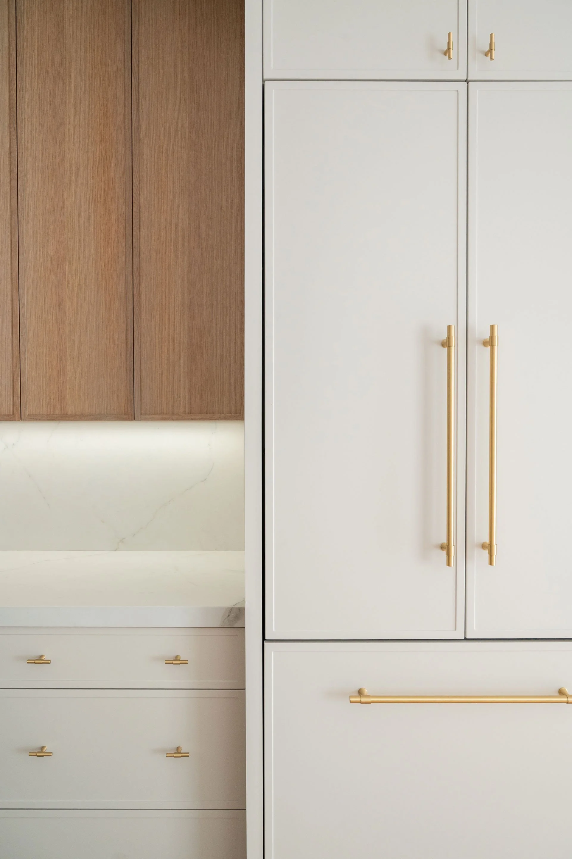 Panel ready fridge with cream slim shaker doors and brass hardware pulls