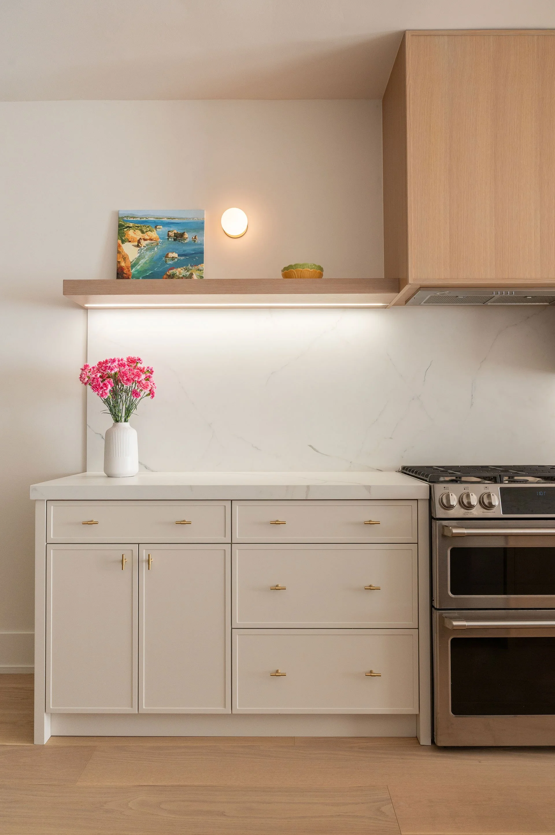 Slim shaker base kitchen cabinets with brass knobs, porcelain countertop and open white oak upper shelving