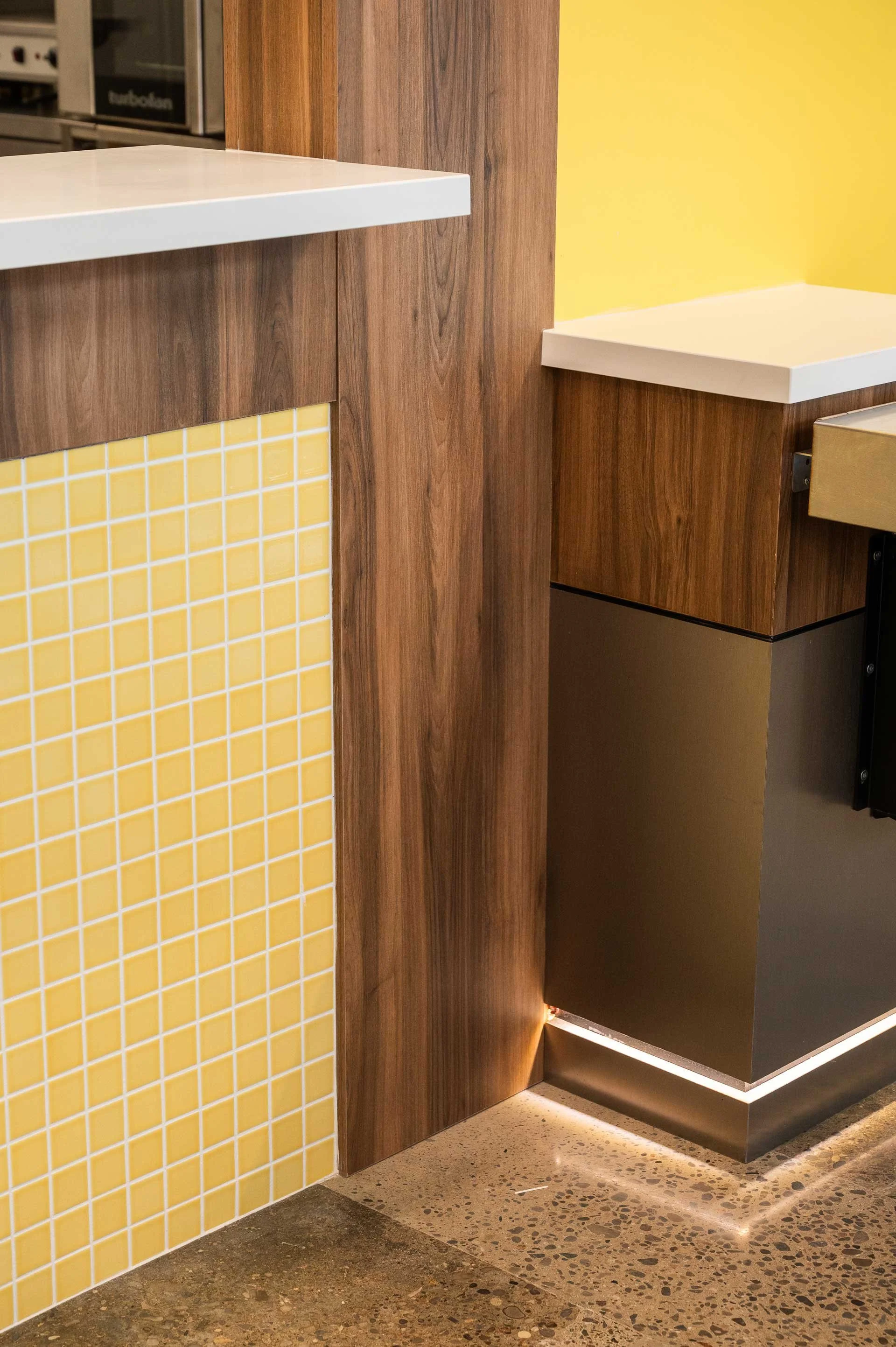 wood clad & yellow mosaic tile wall with stainless steal accent