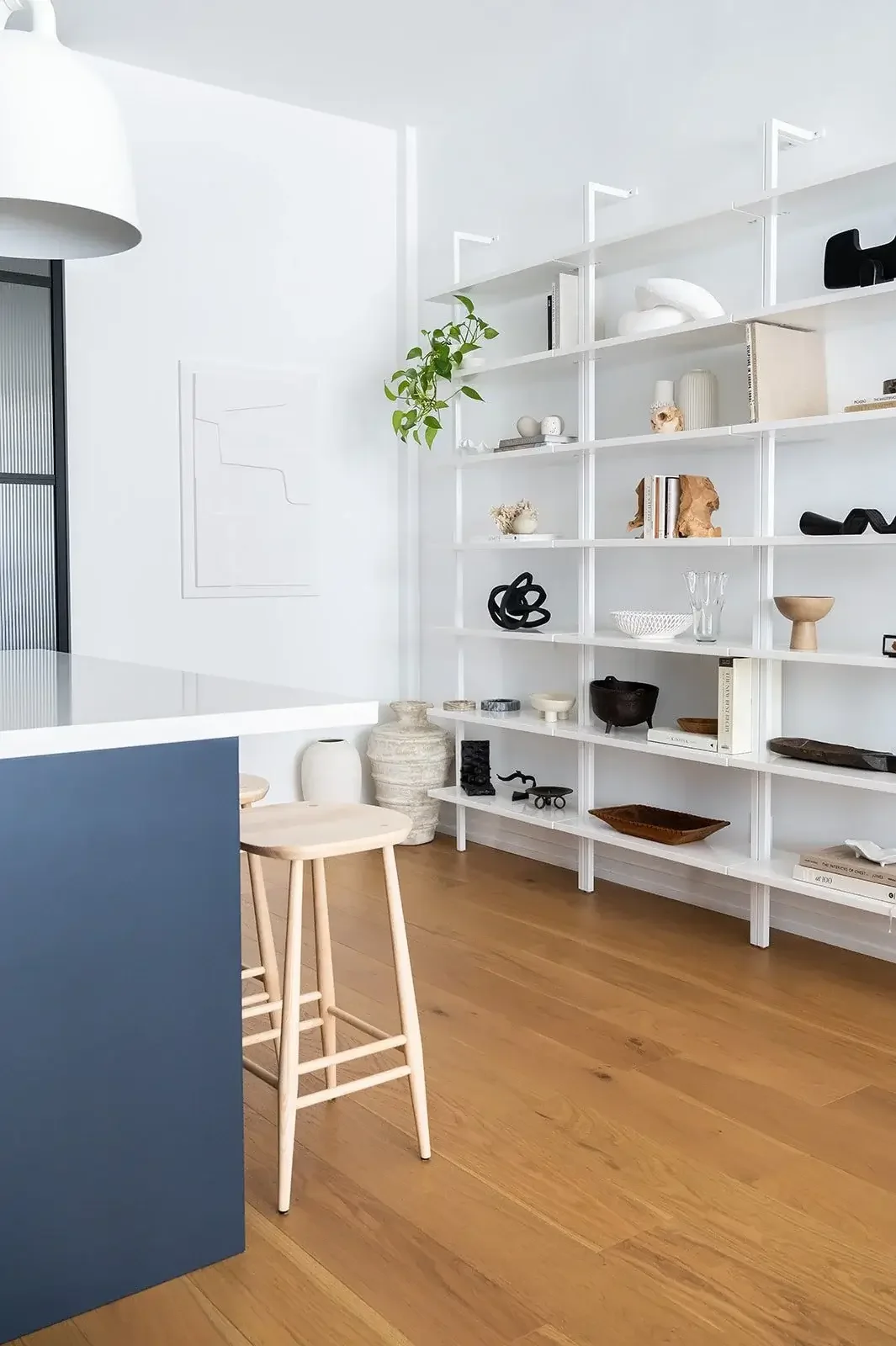 Modern minimalist interior with open shelving, decor styling, and light wood flooring in a Toronto home