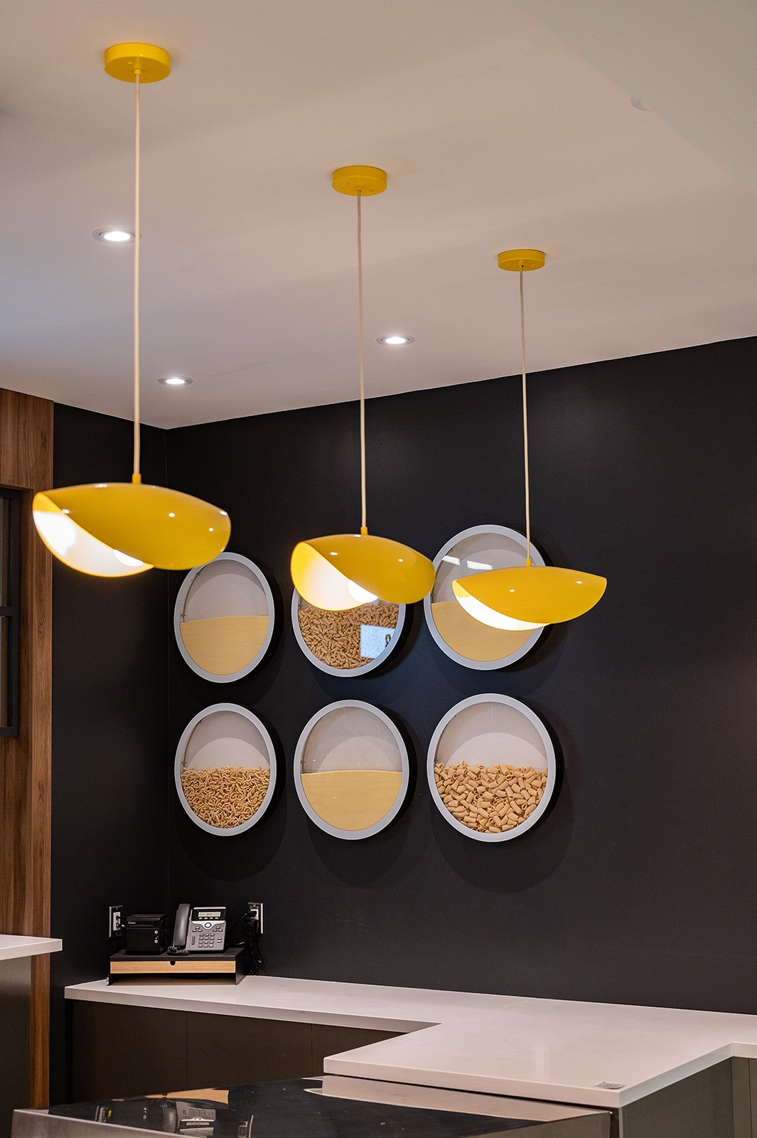 Yellow pasta shaped pendants Infront of pasta wall art