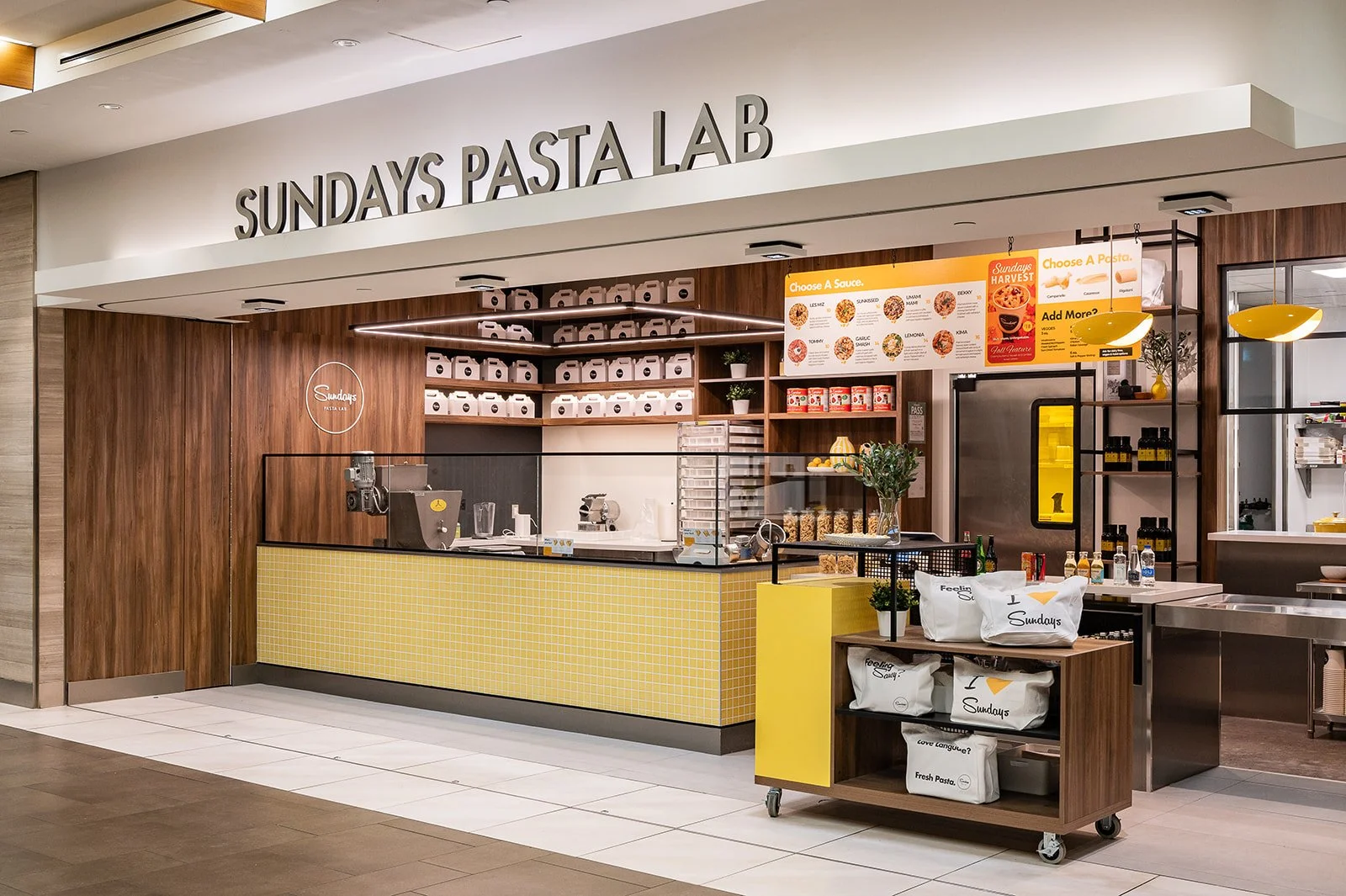 Industrial style pasta restaurant with pops of yellow and walnut wood